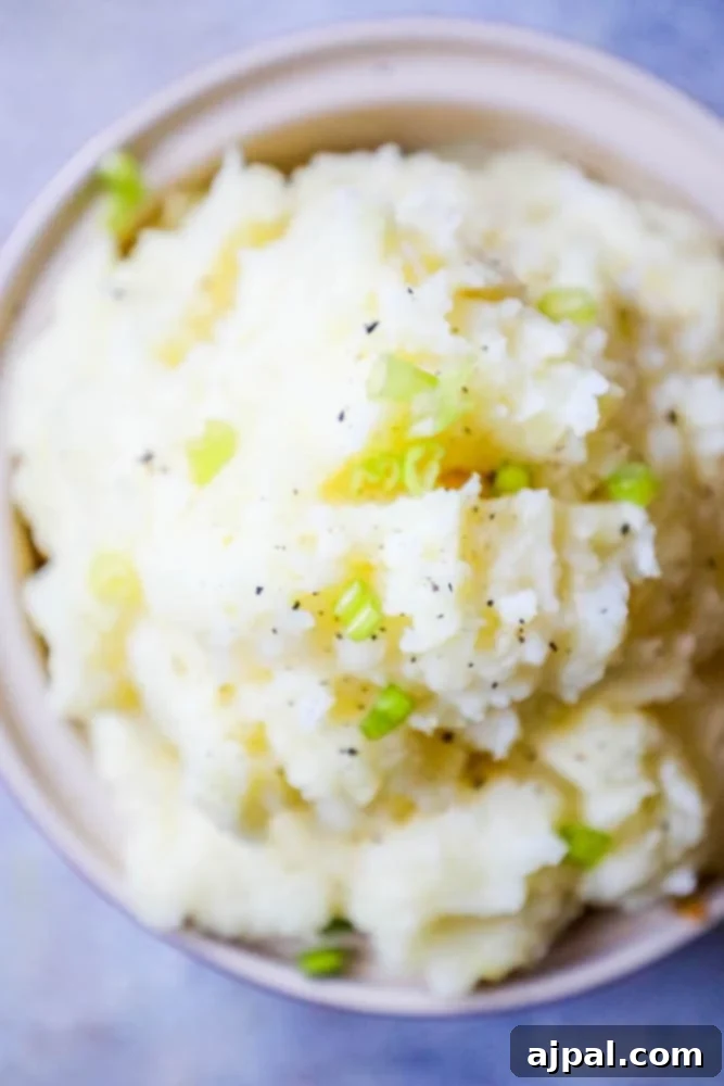 Creamy Slow Cooker Mashed Potatoes 3 mashed potatoes with green onions in a white bowl