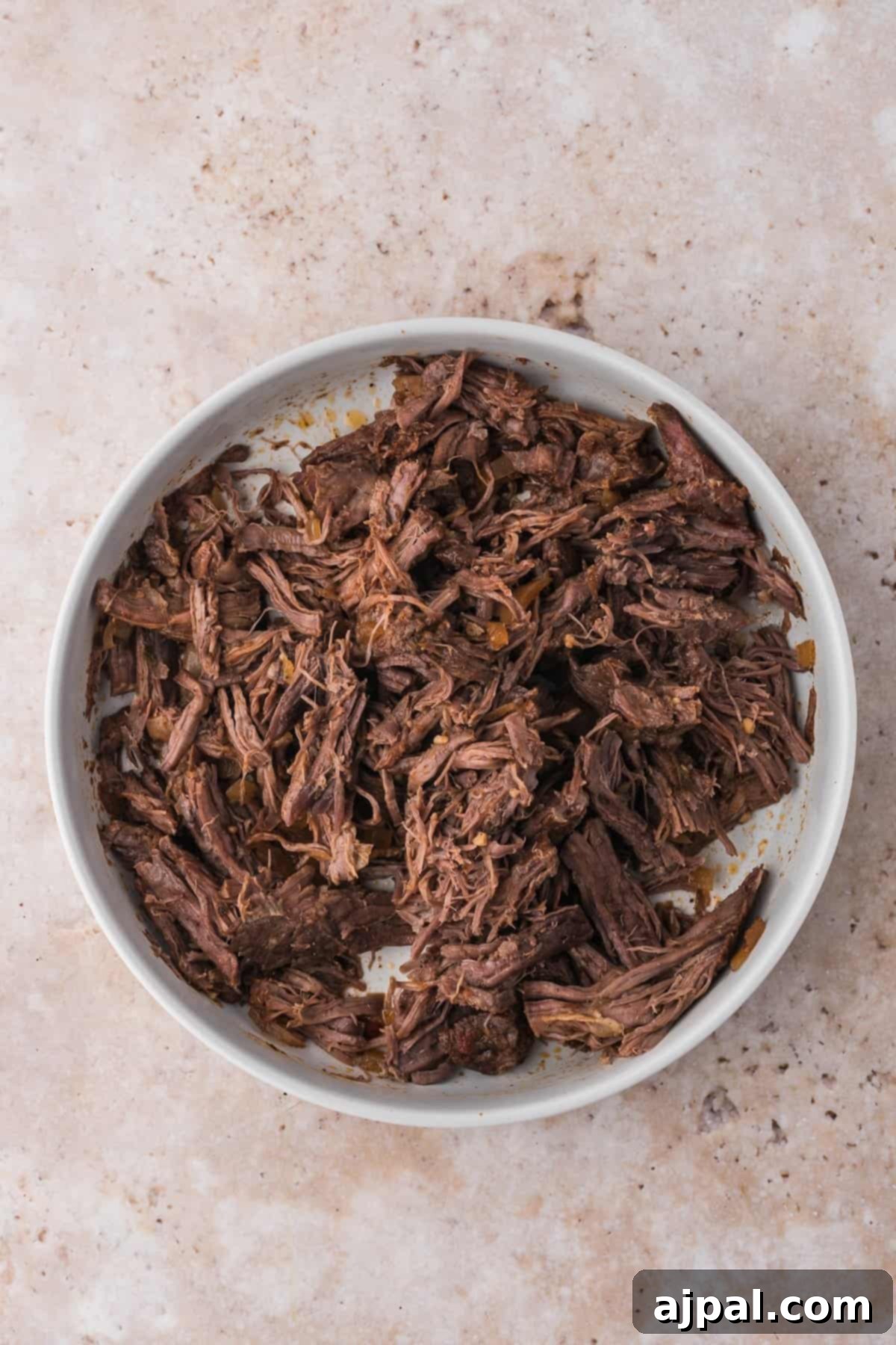 Tender Braised Beef Tacos 9 Perfectly cooked and tender shredded beef resting in its rich, flavorful juices within the slow cooker, ready to be assembled into delicious tacos.