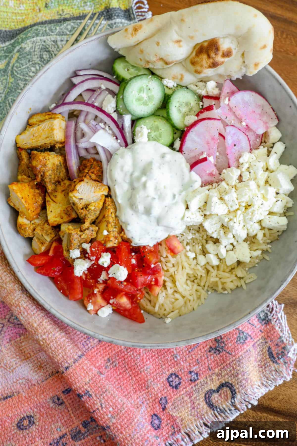 A top-down view of a vibrant Greek Chicken Bowl, showcasing all its fresh ingredients and inviting colors.