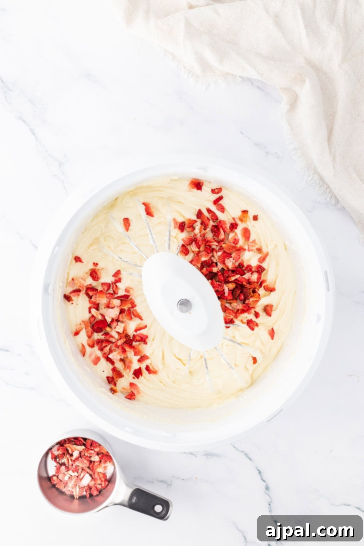 Bowl with strawberries mixed into the cake batter, showing the fruity addition.