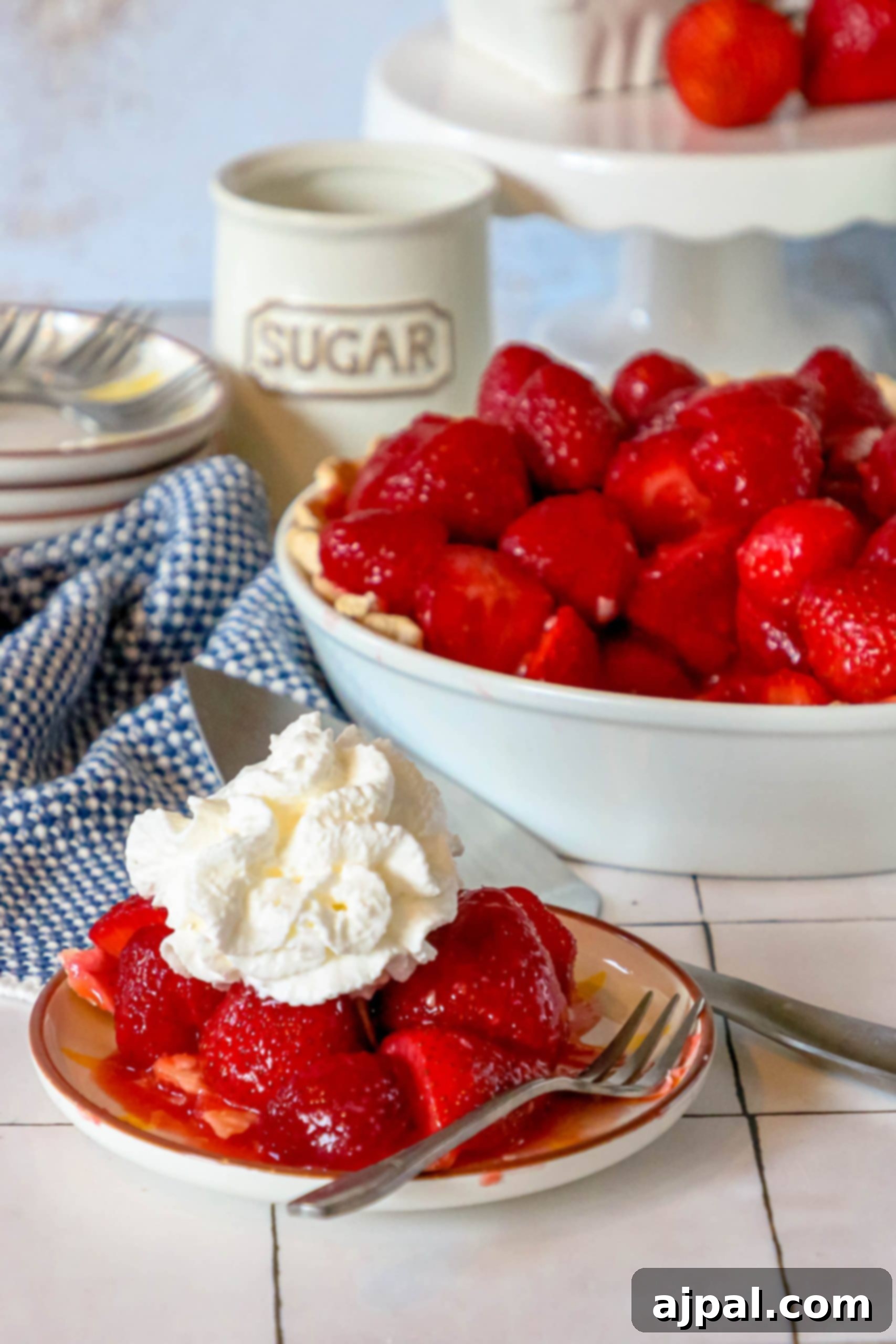 Sweet Summer Strawberry Pie 2 Easy strawberry pie with whipped cream on a plate, showcasing a vibrant red filling and golden crust.
