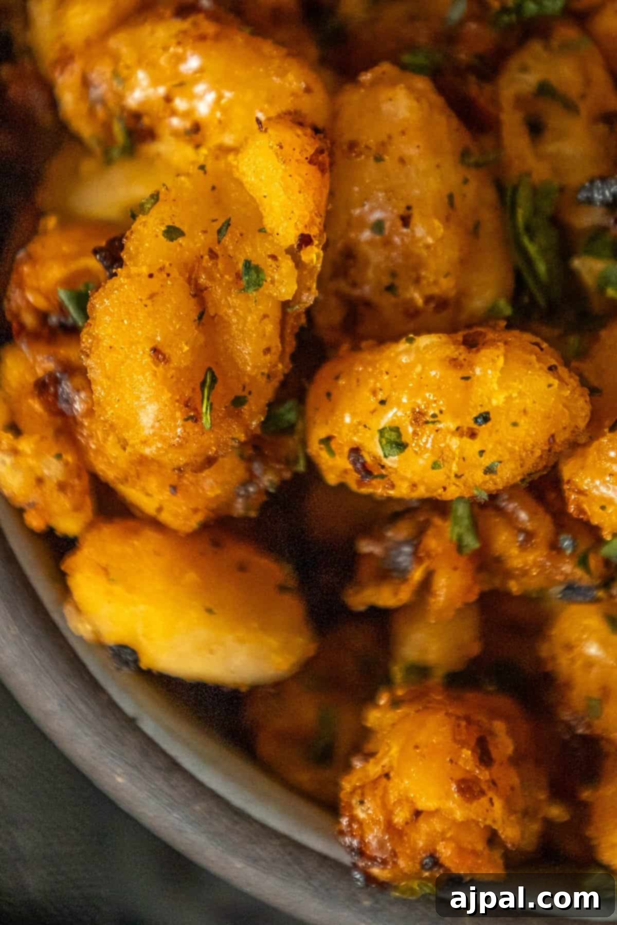 A close-up of crispy roasted white beans coated in chili crisp, served in a small white bowl, ready to be enjoyed as a savory snack or side dish.