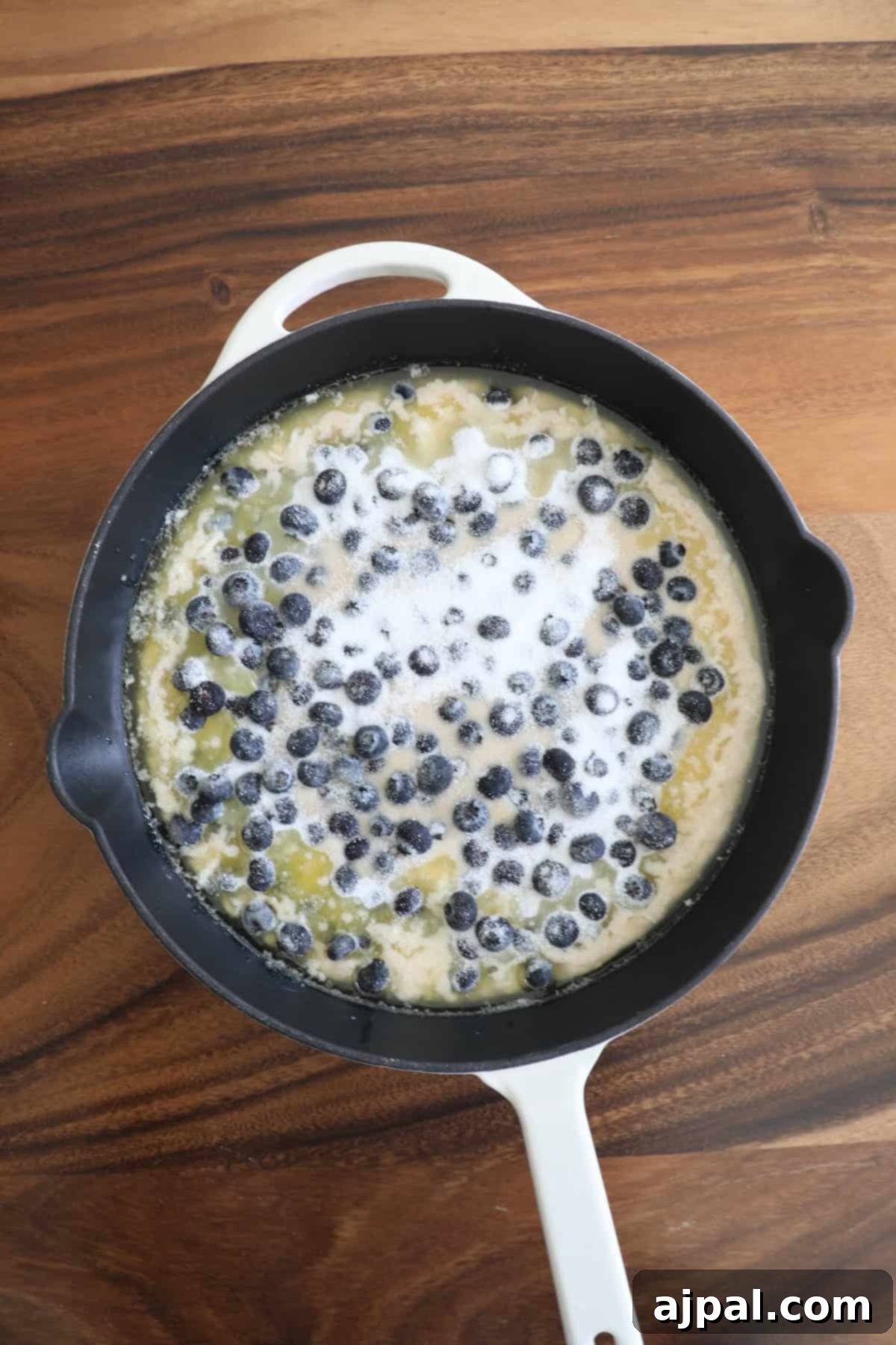 Mixing wet and dry ingredients for blueberry cobbler in a bowl.