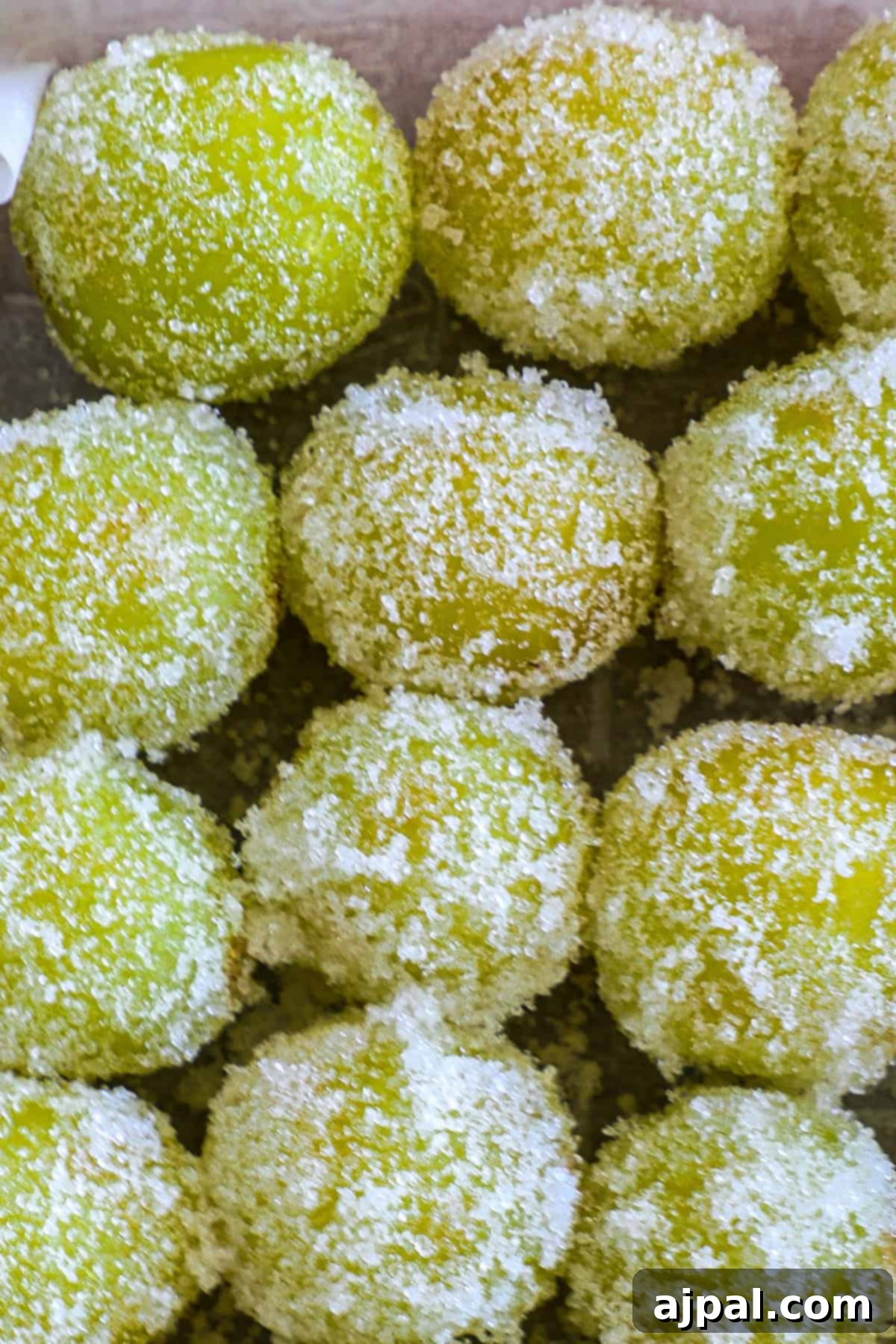 Zingy Sweet Grapes 2 Close-up of sugared green candies piled together, with focus on their textured sugar coating.