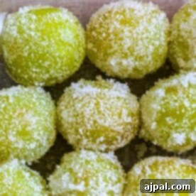 Close-up of sugared green grapes covered in granulated sugar crystals, focusing on their textured surfaces.