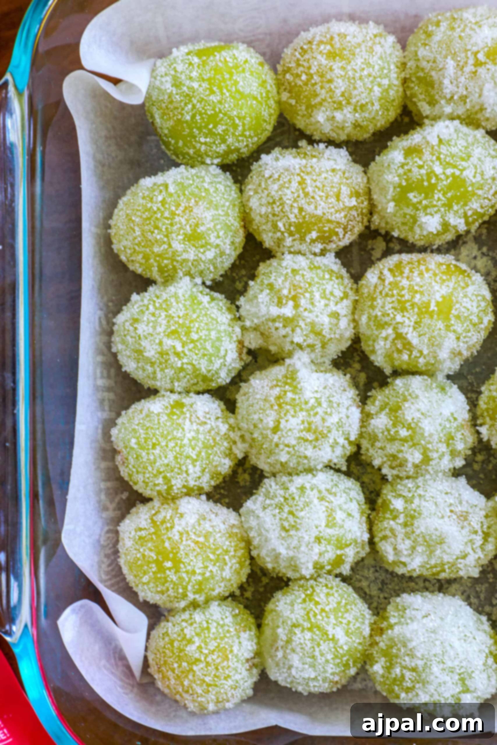 Zingy Sweet Grapes 4 Green sugared candies in a baking dish lined with parchment paper.