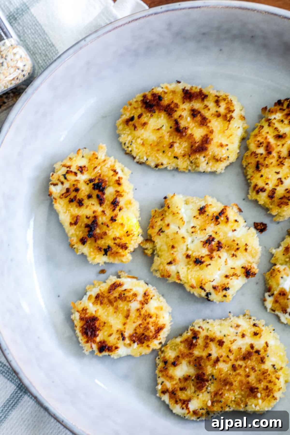 A pristine white ceramic dish holds a plate of golden-brown crusted chicken cutlets, perfectly cooked and ready to serve.
