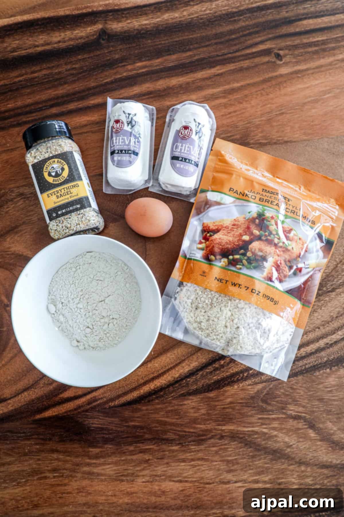 Various baking ingredients, including an egg, flour, and seasoning packets, are neatly arranged on a rustic wooden surface.