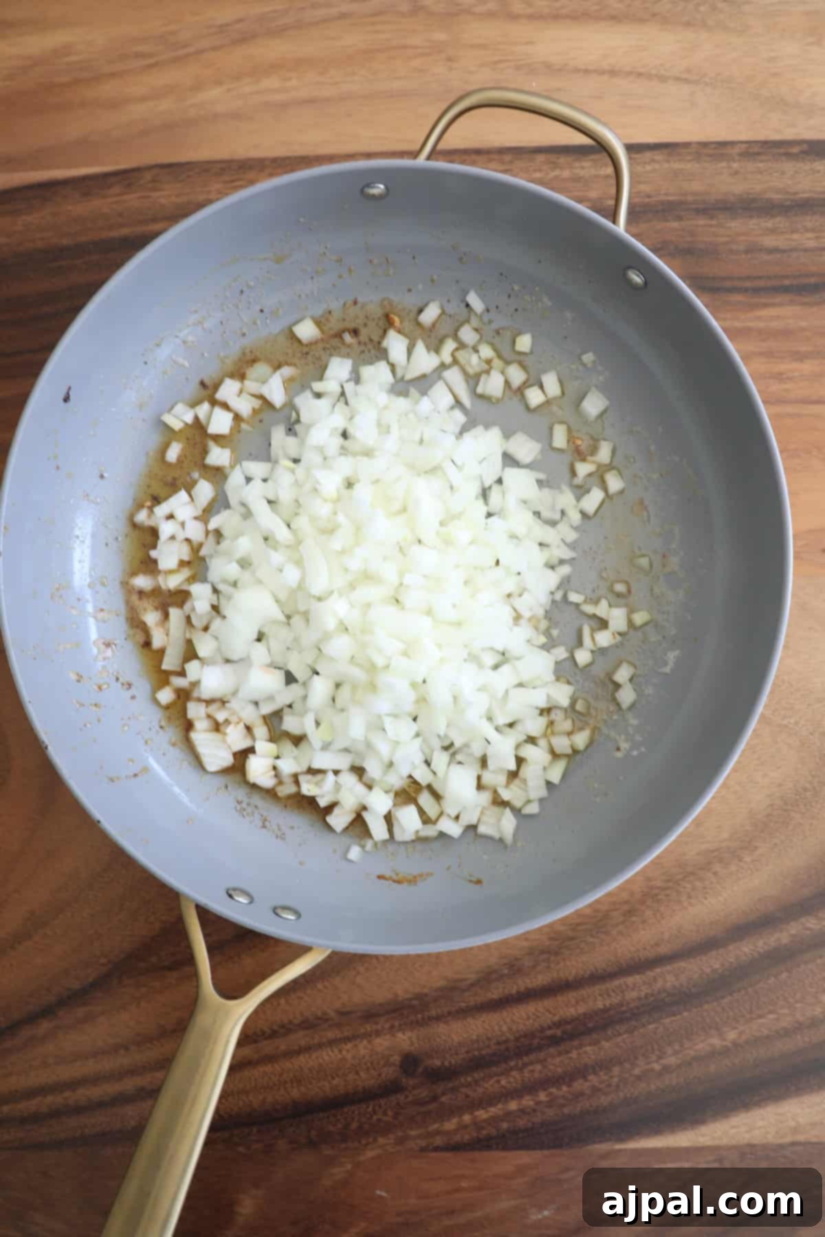 Orzo pasta cooking in chicken broth, absorbing flavors in a pan.