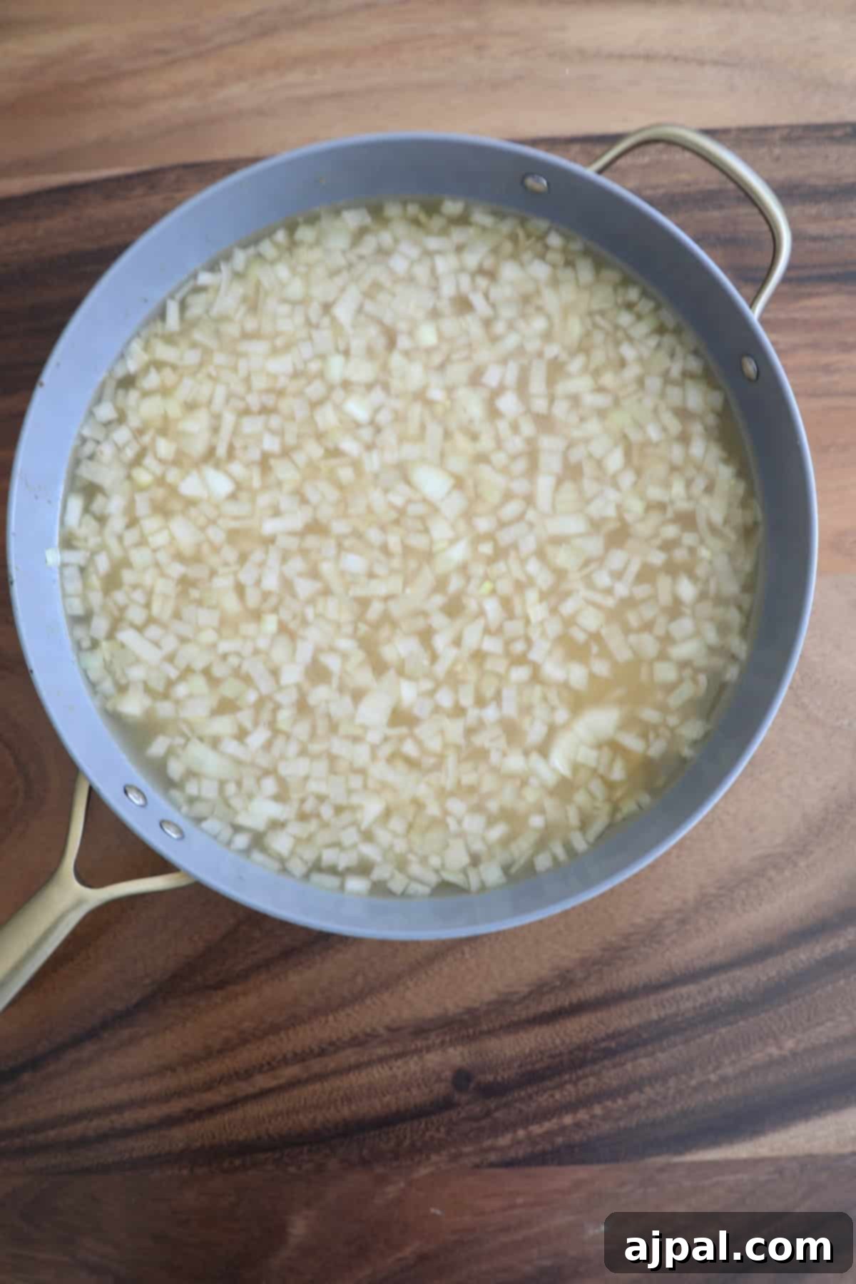 Adding heavy cream and Parmesan cheese to the orzo pasta in a pan.