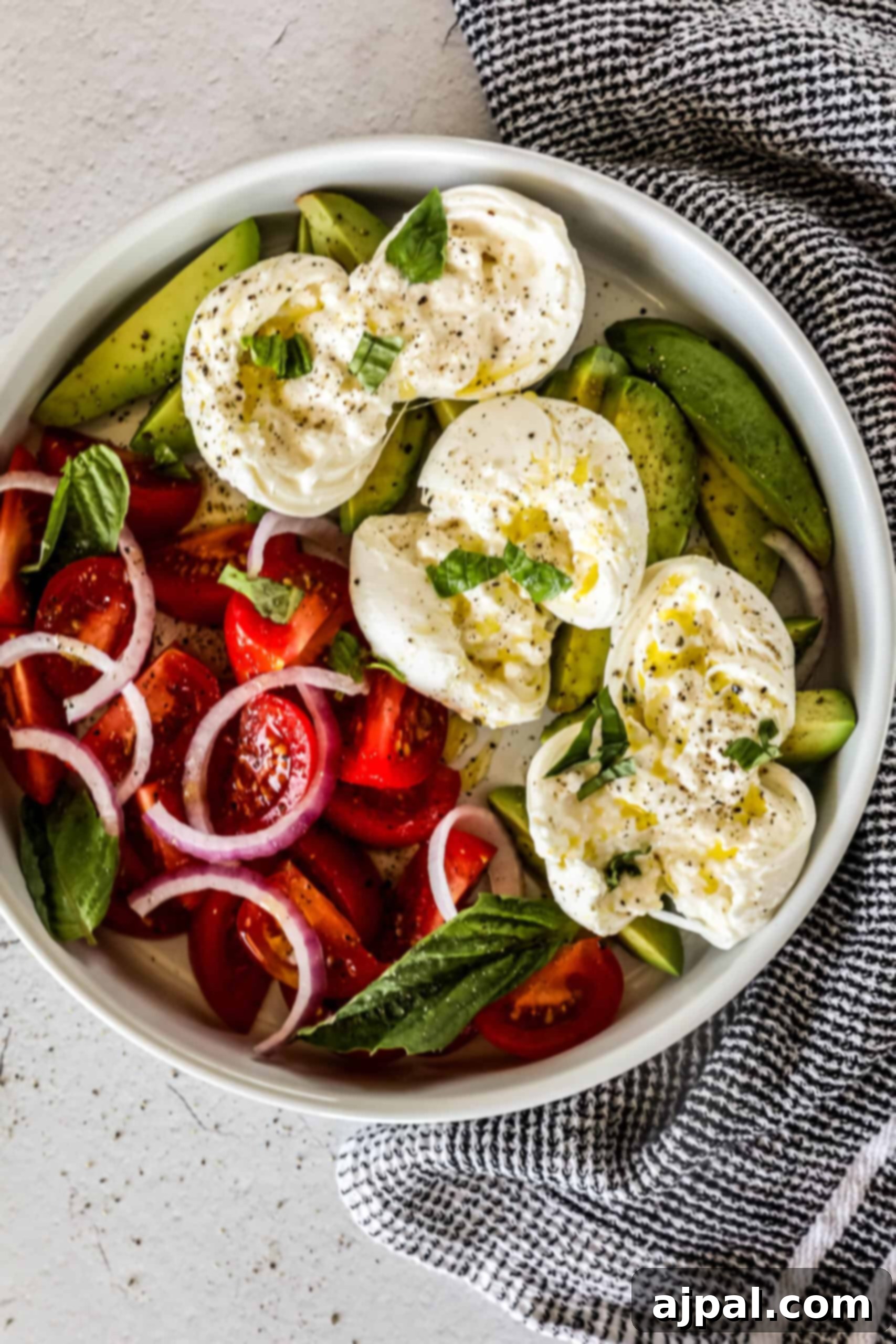 Creamy Burrata Avocado Tomato Salad 6 A vibrant and generously portioned Burrata Tomato and Avocado Salad, artfully arranged on a rustic wooden board, ready to be enjoyed.