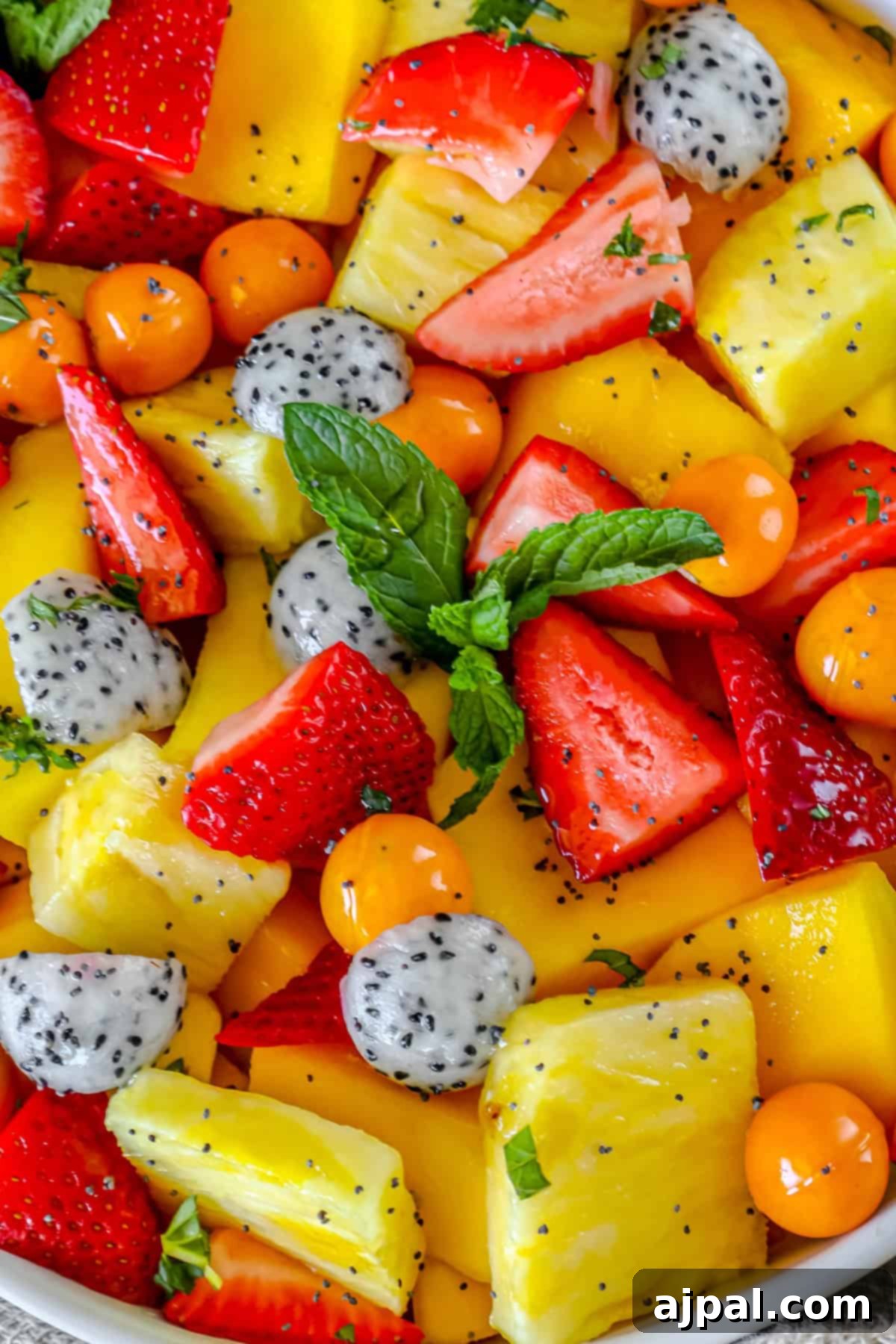 Paradise Fruit Medley 2 A large bowl filled with colorful tropical fruit salad, including chunks of pineapple, slices of kiwi, red strawberries, and vibrant dragon fruit. A spoon is resting in the bowl, ready to serve.