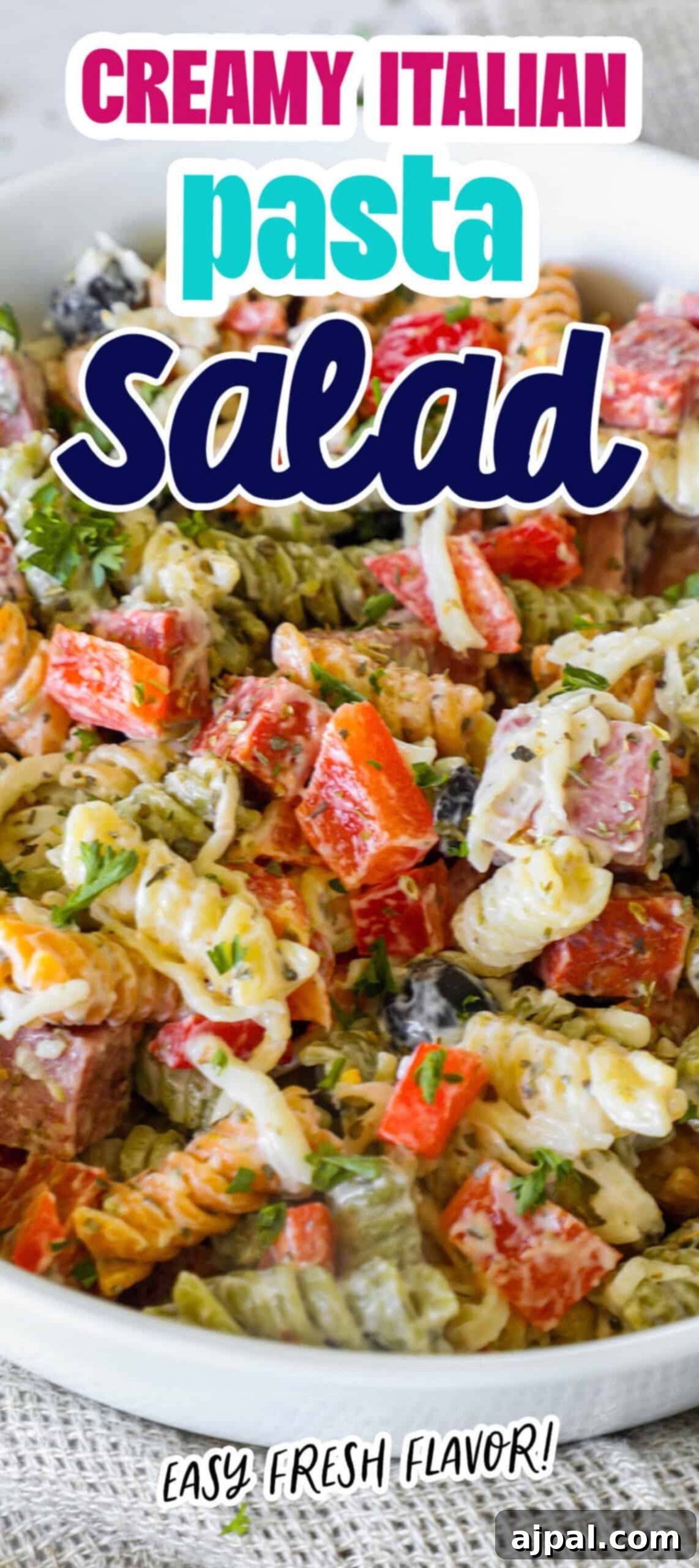 Creamy Italian Pasta Salad 9 A beautifully presented bowl of creamy Italian pasta salad on a rustic wooden table, with fresh herbs and a vibrant mix of ingredients visible.