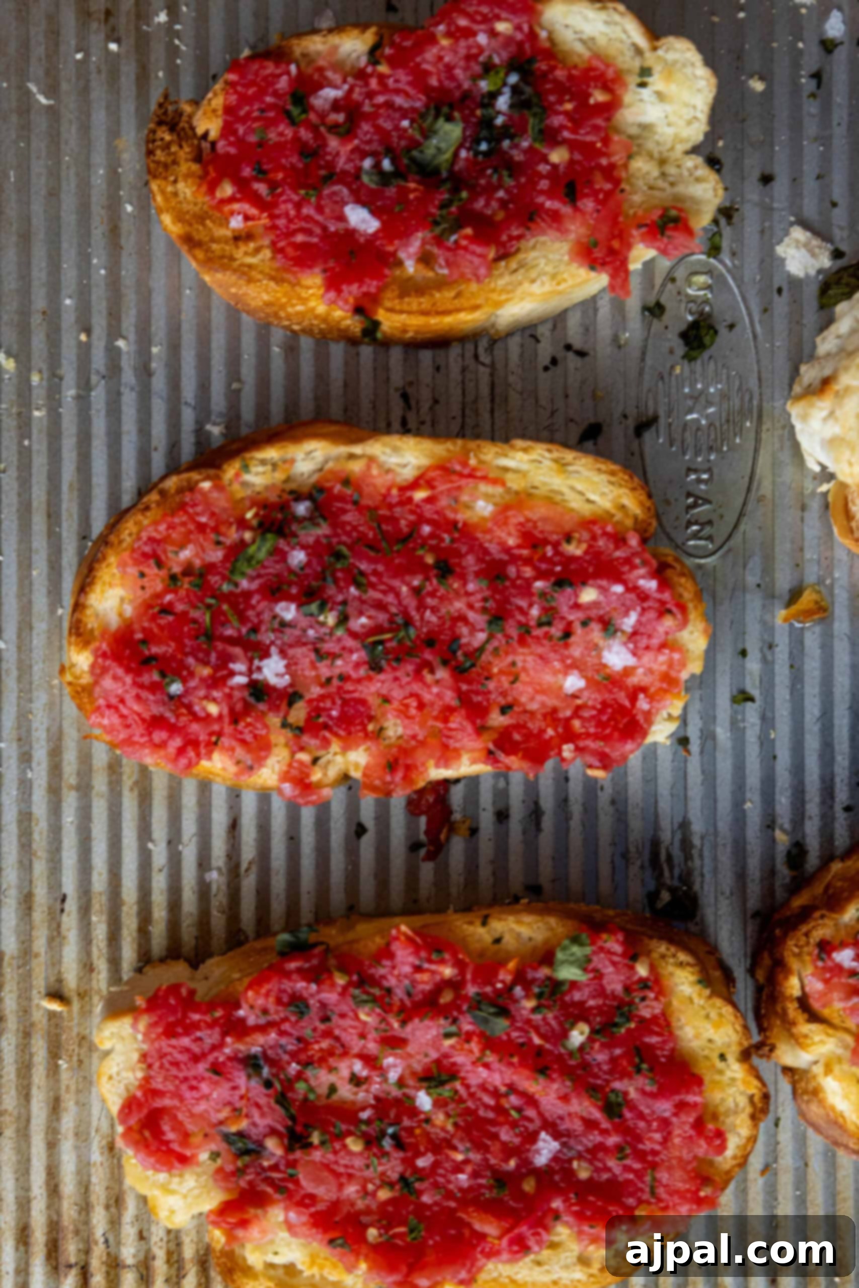 Finished Pan con Tomate slices on a plate, garnished with basil and a drizzle of olive oil.