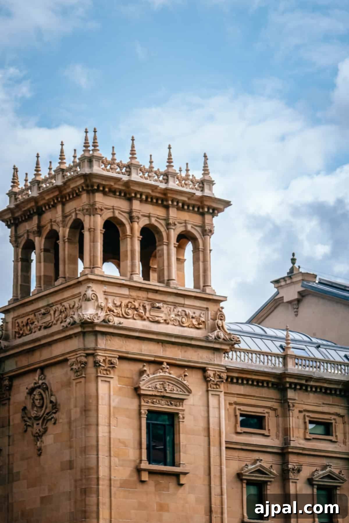 A vibrant street scene in a historic Basque town, with ornate architecture, colorful flags, and lively activity, inviting travelers to explore the rich culture.
