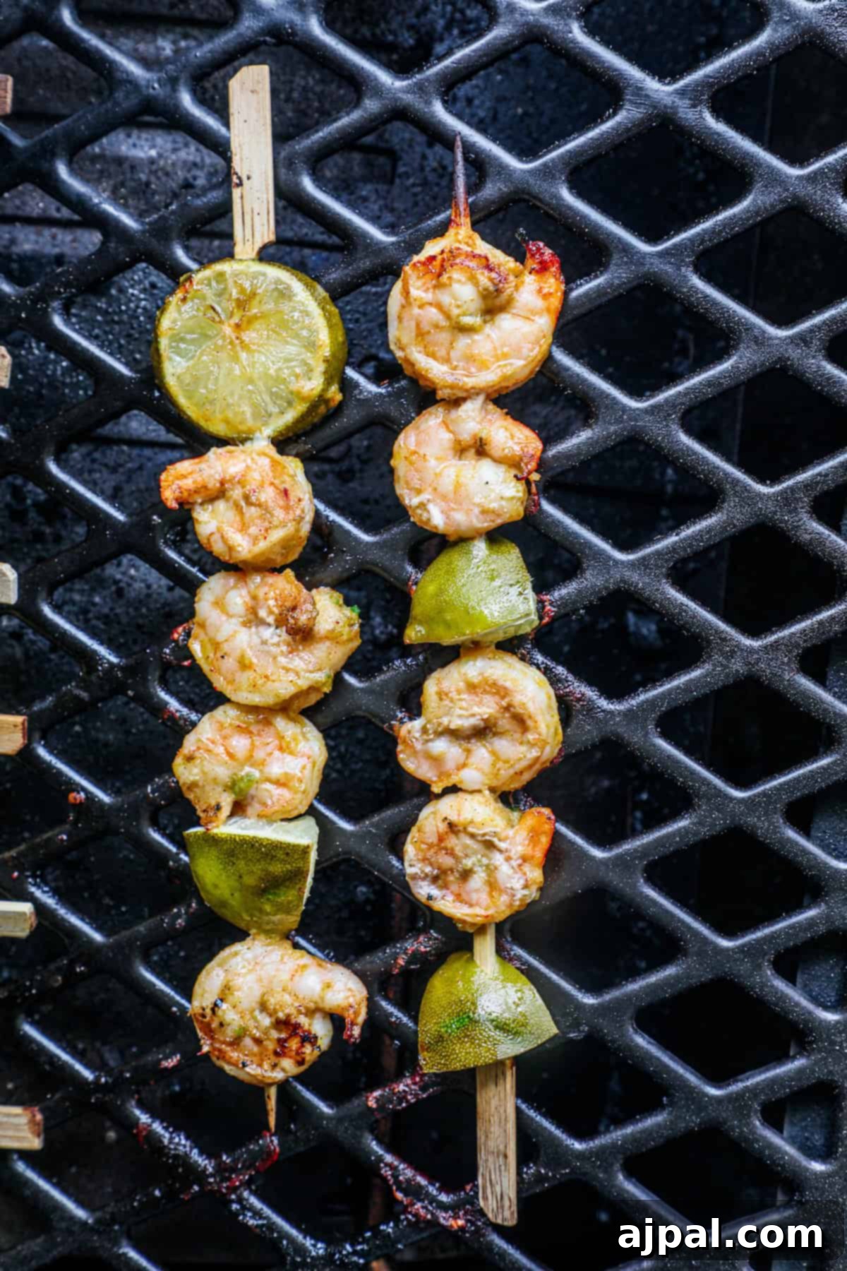Zesty Margarita Grilled Shrimp 4 Marinated shrimp threaded onto skewers with lime slices, ready for grilling.