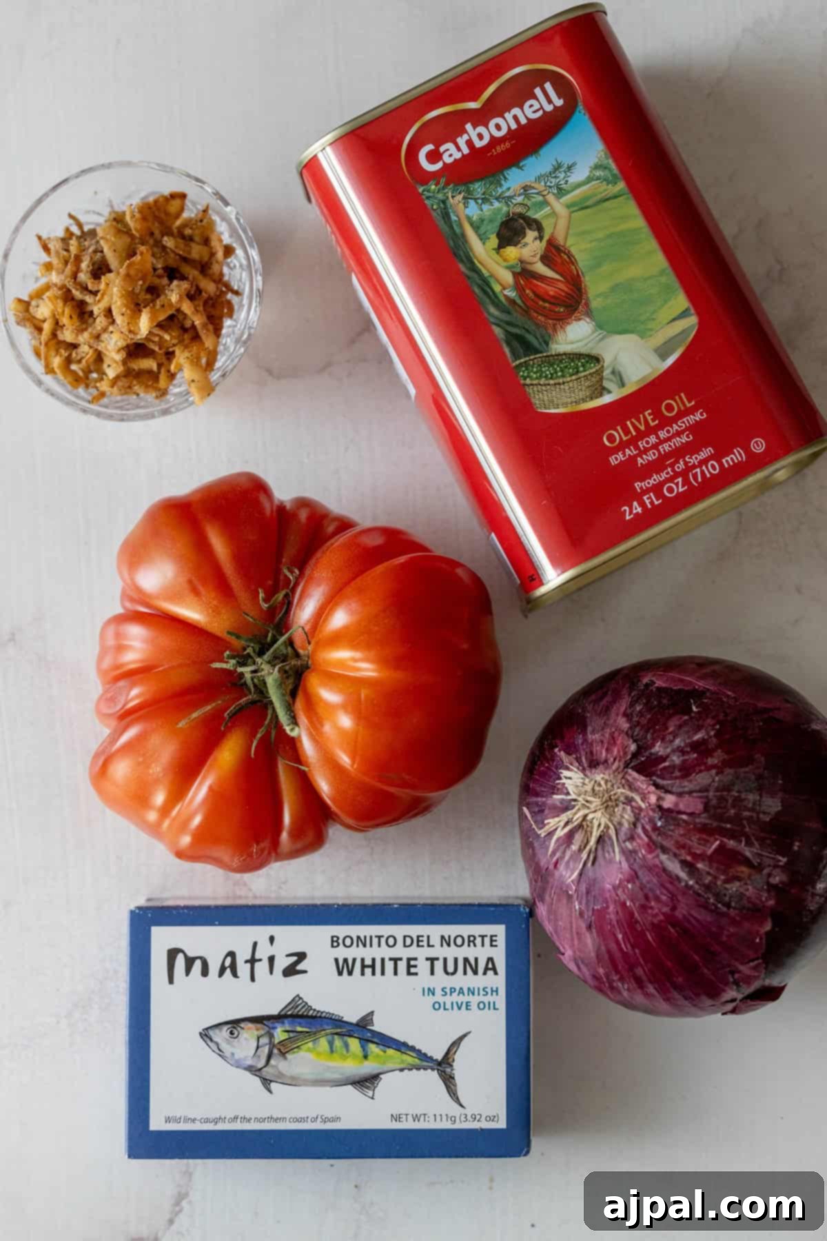 A vibrant Spanish tomato salad, featuring thinly sliced tomatoes, red onions, and a rich olive oil dressing.