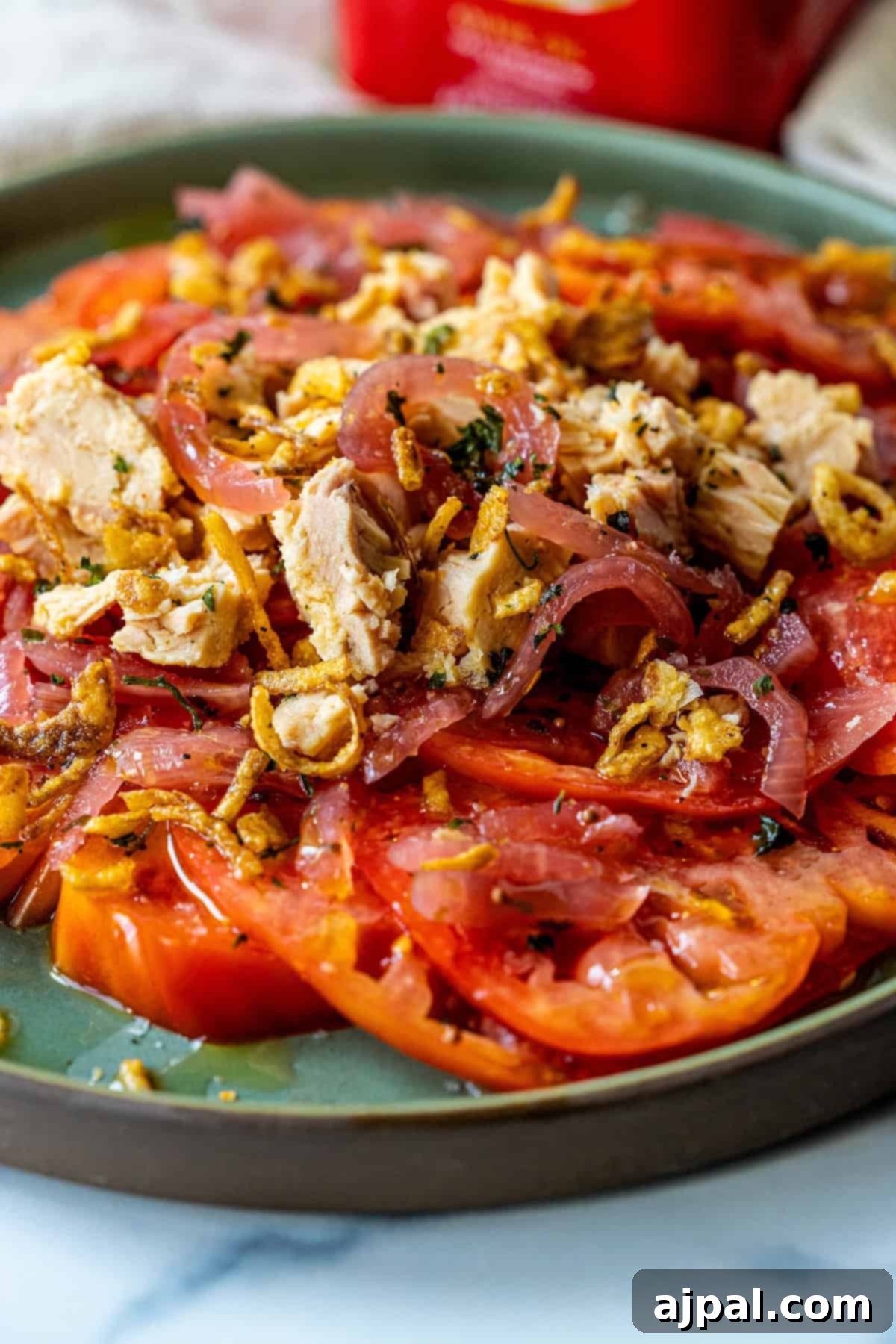 Spanish tuna and tomato salad served in a elegant glass bowl, with a focus on its freshness and vibrant colors.