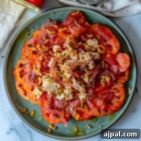 A plate with a refreshing tuna salad featuring shredded chicken, marinated onions, herbed seasoning, and a drizzle of dressing.