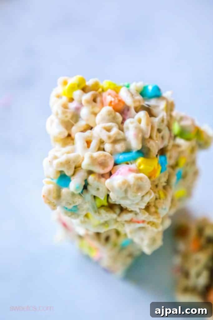 Lucky Charms treats - no bake marshmallow and butter lucky charms treats for Saint Patricks Day Stacked Lucky Charms treats on a table, showcasing their colorful appeal