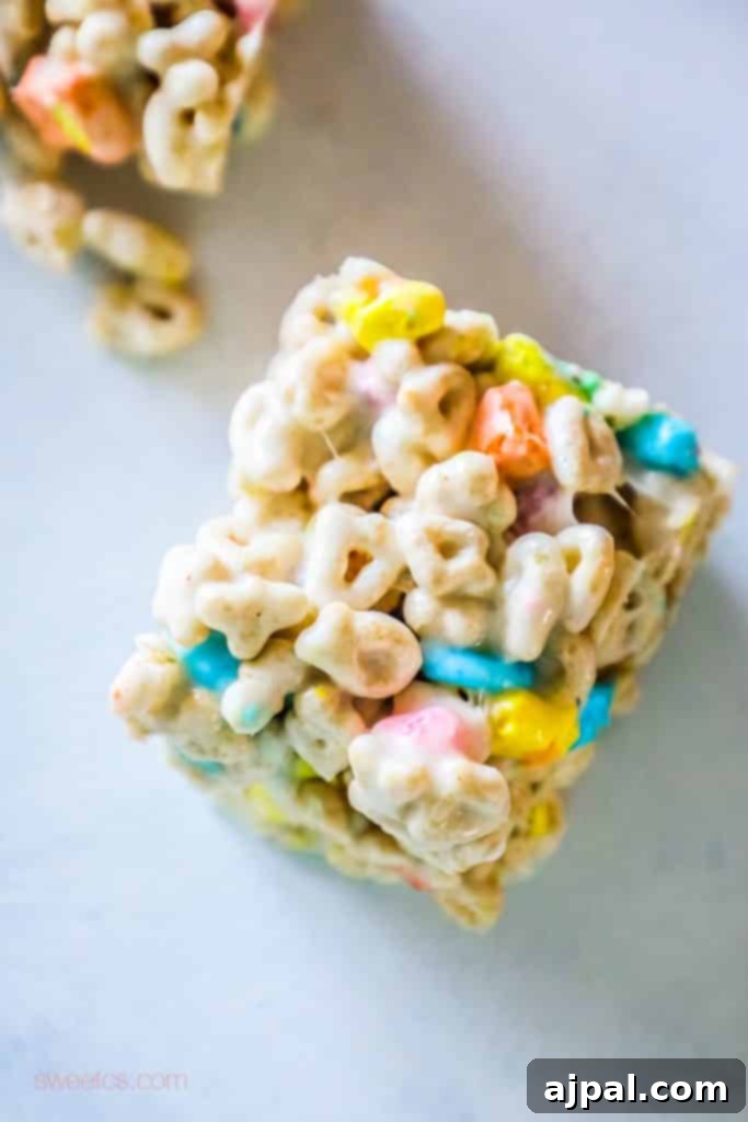 Easy Saint Patricks Day No Bake Lucky Charms Treats Recipe Picture Lucky Charms treats piled on top of each other on a table, showcasing a generous serving