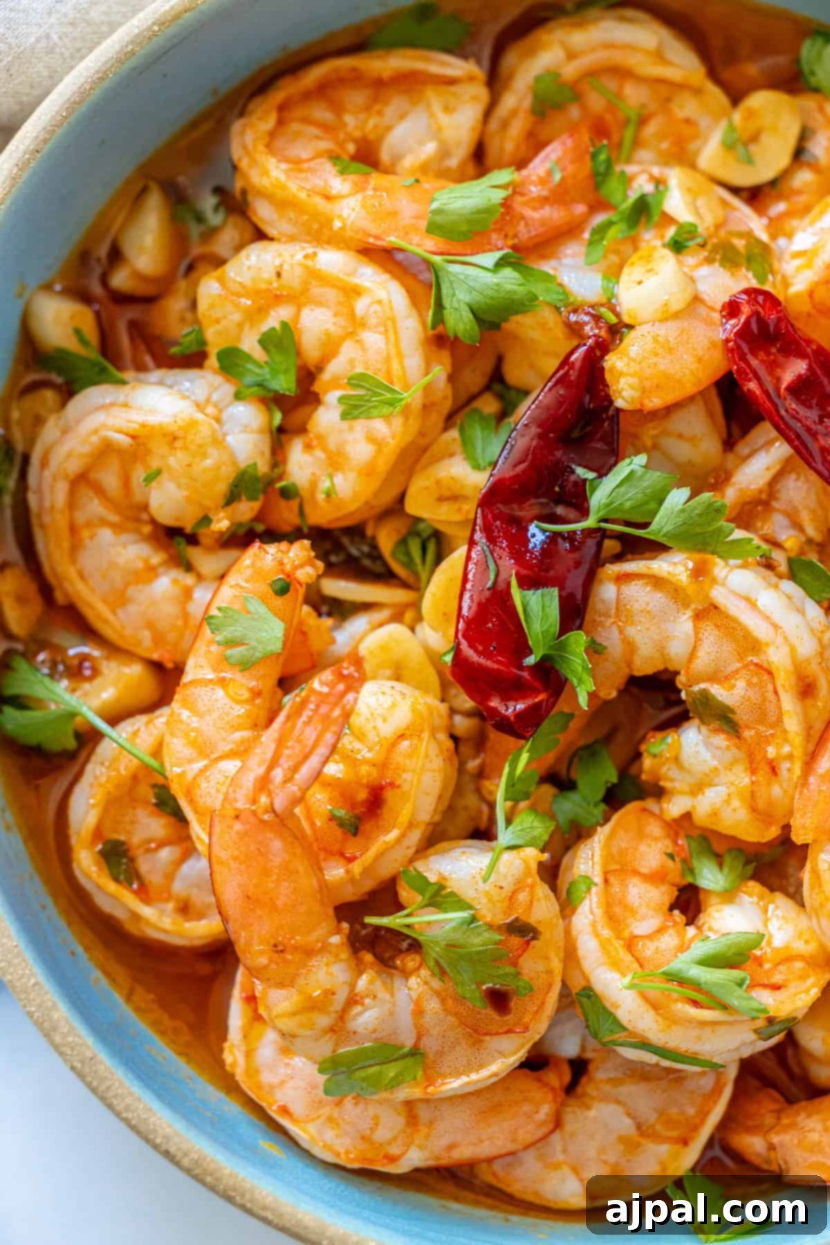 Close-up of a sizzling Gambas Pil Pil dish, capturing the steam and vibrant colors, ready to be served.