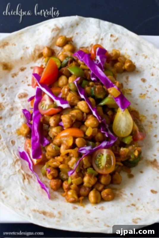 A perfectly wrapped vegan chickpea burrito, elegantly presented on a clean white plate, ready to be enjoyed.