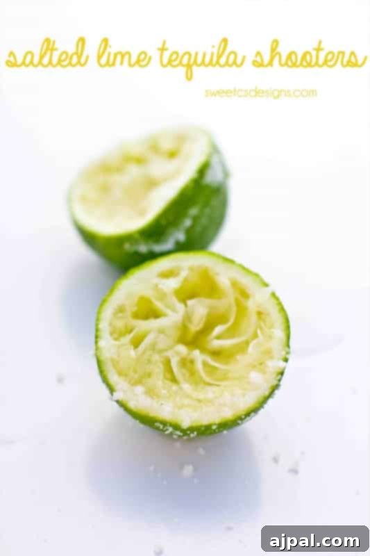 Tequila's Zesty Salted Kiss 2 A vibrant, freshly squeezed lime half, generously rimmed with glistening cocktail salt, ready to hold a tequila shooter. Perfect for a zesty party.