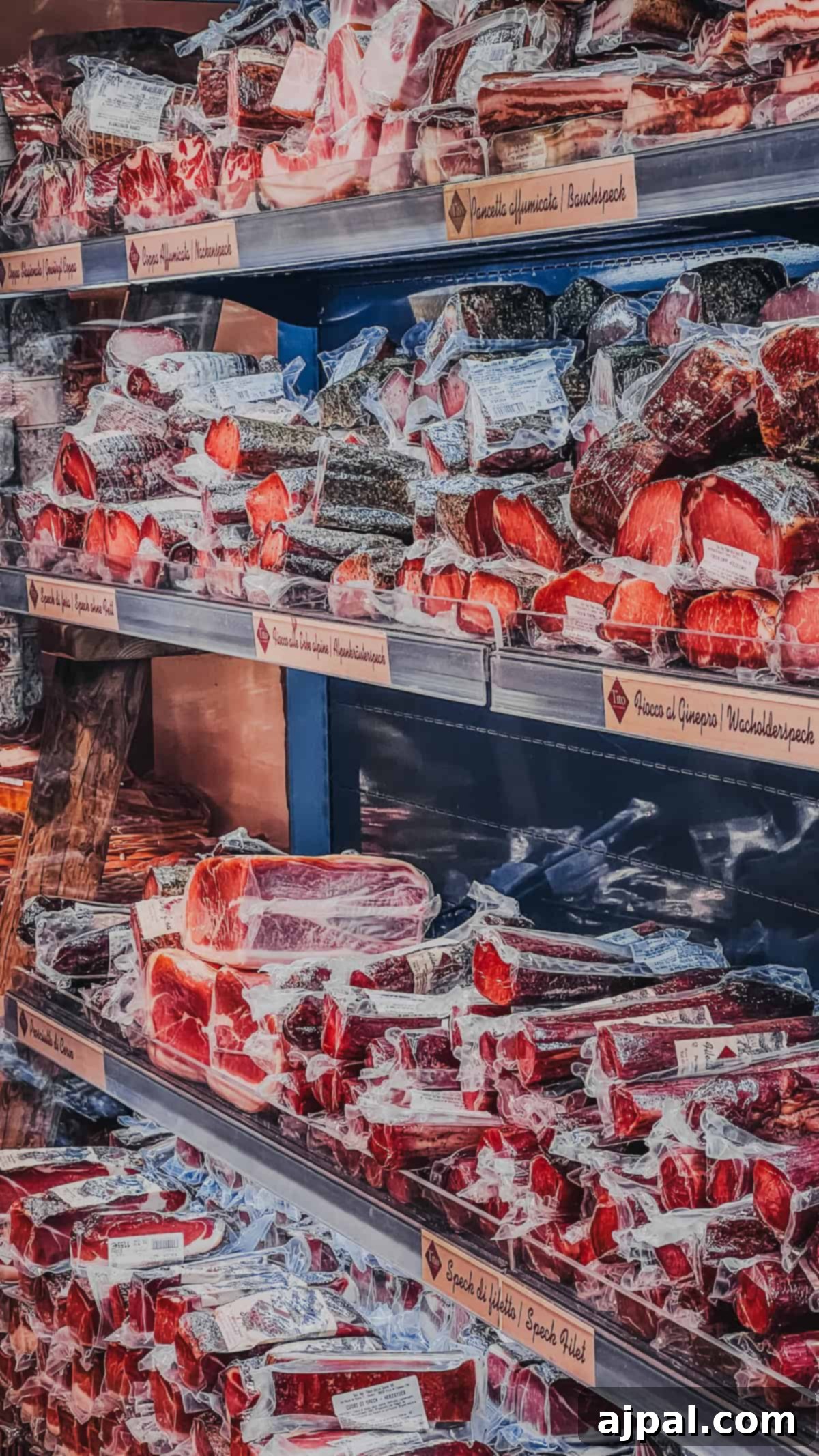 Bolzano's Magical Christmas Market 8 Shelves in Bolzano's market are stocked with various vacuum-sealed cured meats and sausages in a festive display, perfect for Christmas shopping.