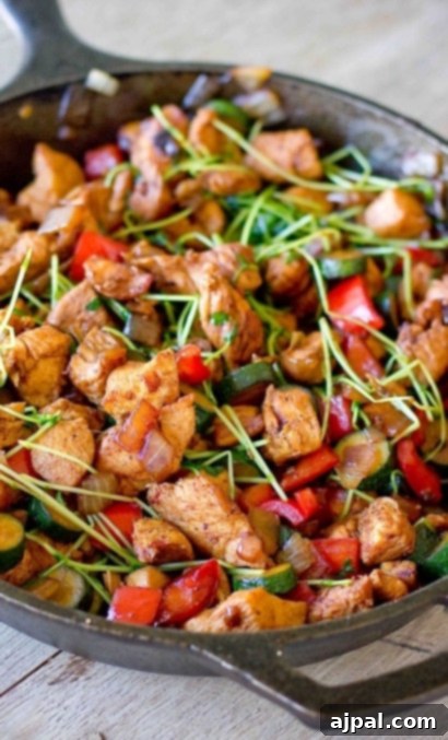 Vibrant keto Asian stir fry with chicken and colorful vegetables sizzling in a pan, a healthy and quick meal option.