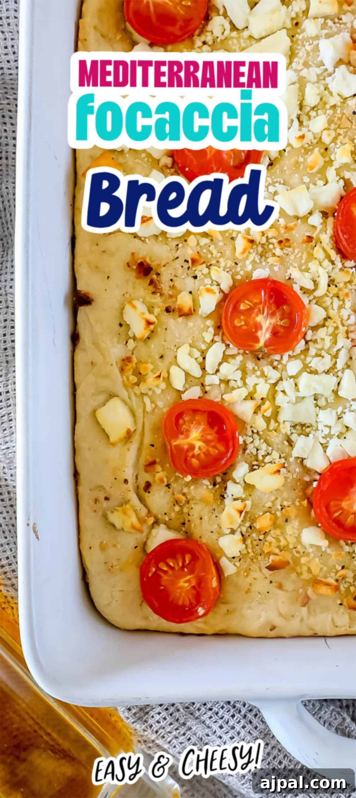 A dish of Mediterranean focaccia bread topped with cherry tomatoes and cheese sits invitingly in a white baking tray. The image features text that reads "Mediterranean focaccia bread" and "Easy & Cheesy!.
