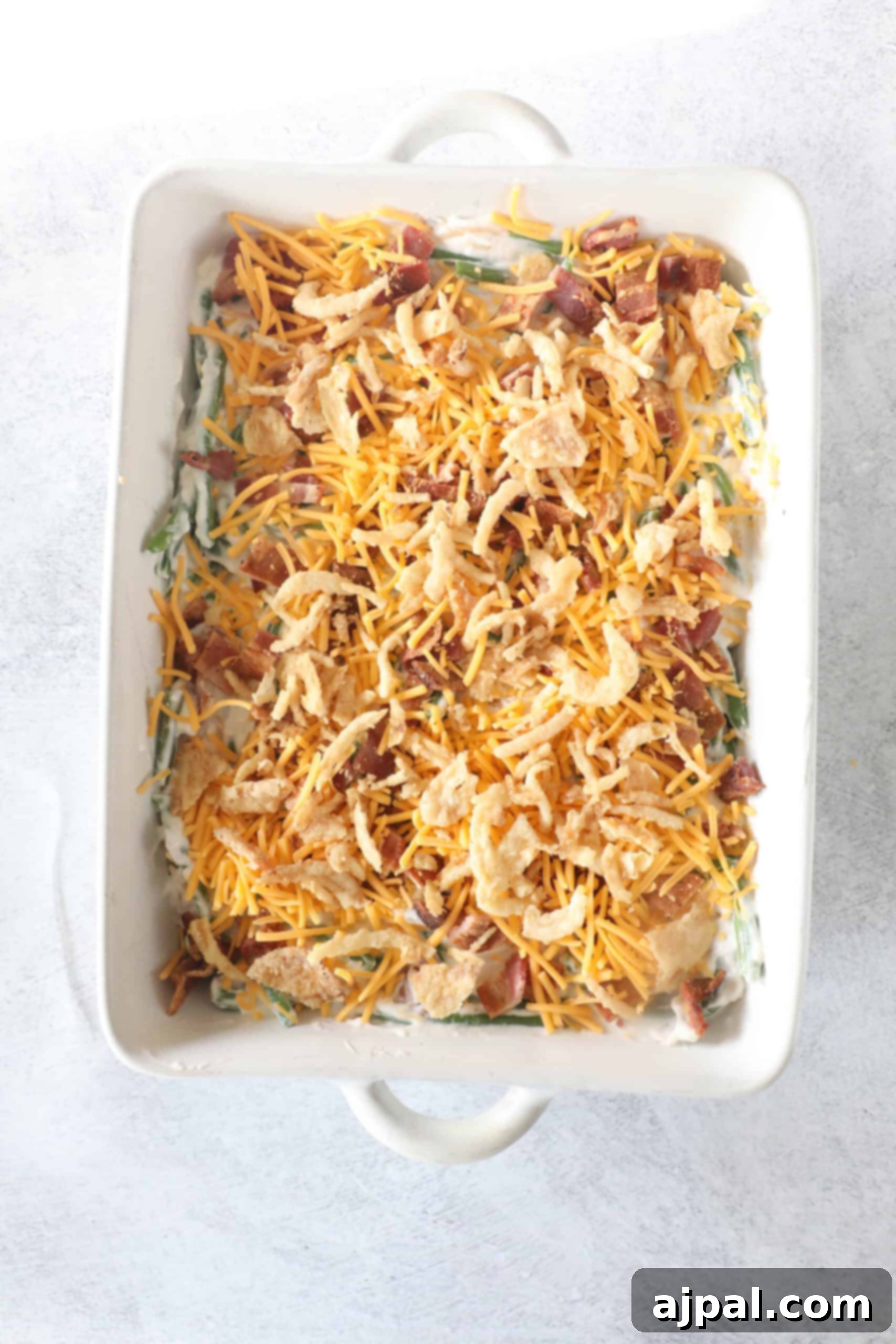 Ultimate Green Bean Bake 8 A casserole dish with a creamy green bean mixture and a light sprinkle of cheese.