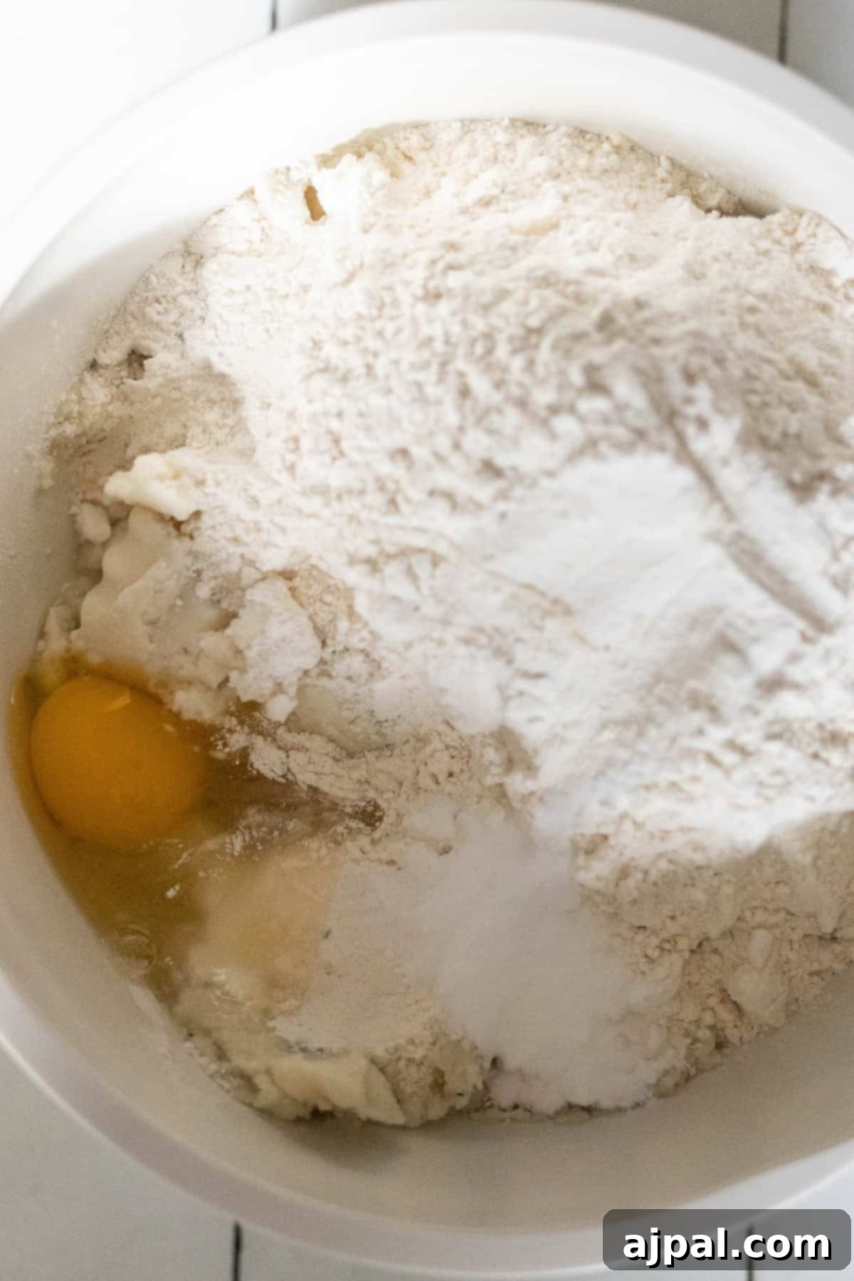 Classic Scottish Tattie Scones 4 A mixing bowl containing flour, an egg, and other baking ingredients is ready to create delicious Scottish tattie scones.