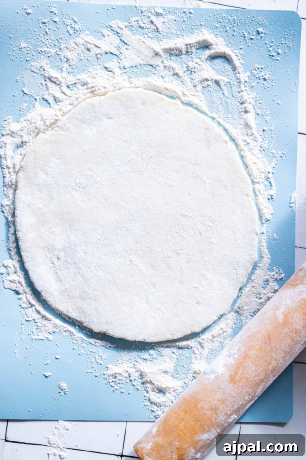 Classic Scottish Tattie Scones 6 A circular sheet of dough on a floured surface, perfect for crafting authentic Scottish Tattie Scones, sits next to a well-used rolling pin.