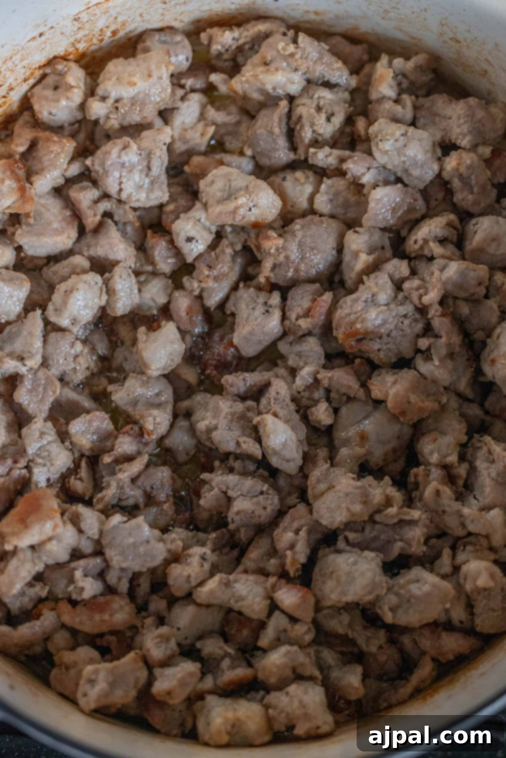 A hearty pot of Polish Bigos, also known as Hunter's Stew, features tender chunks of cooked meat mingling with rich flavors, creating a warm and comforting dish.