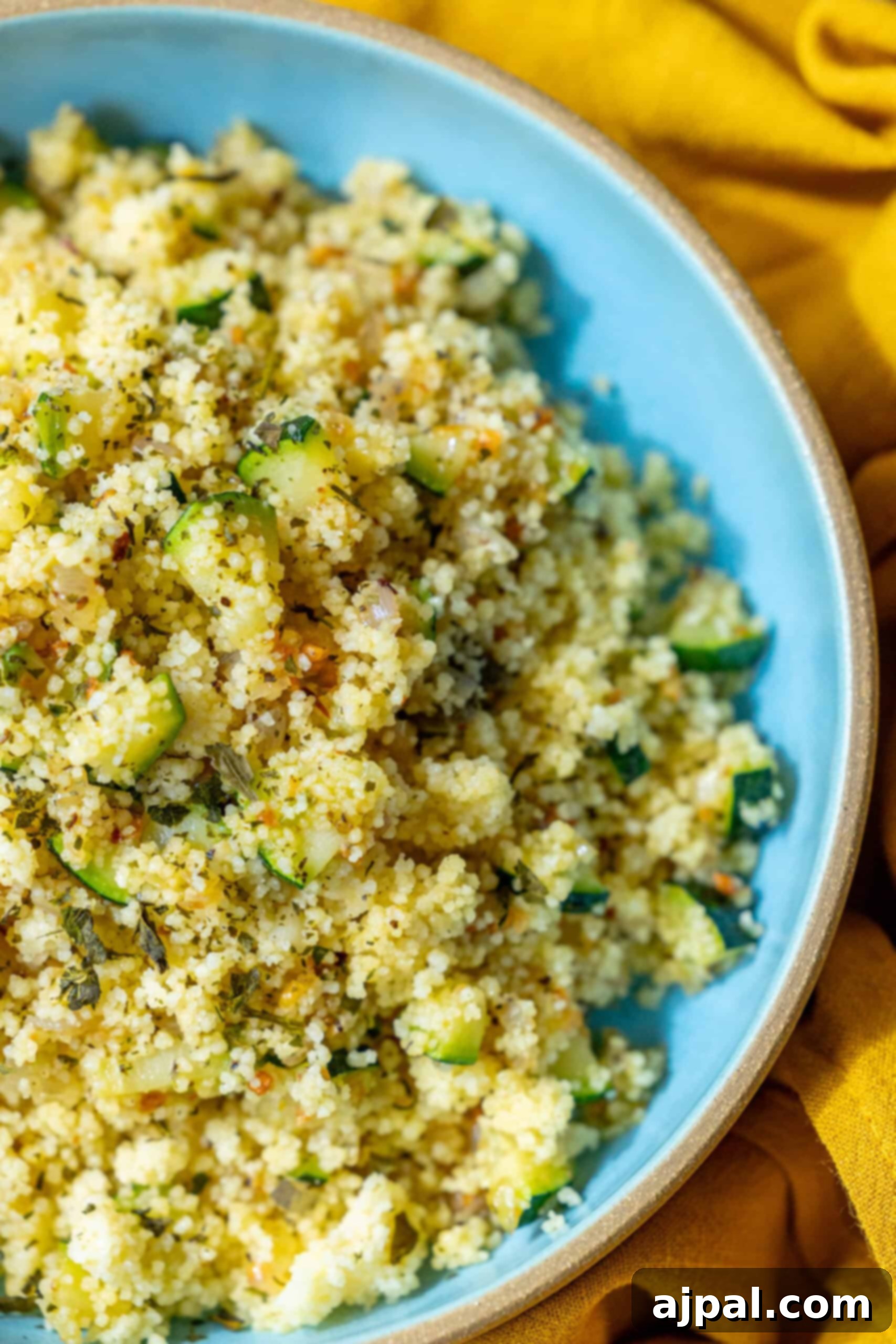 Zucchini Couscous Salad 2 A vibrant bowl of Zucchini Couscous, featuring fluffy grains mixed with tender zucchini, golden shallots, and fresh herbs, ready to be served. The dish embodies fresh, light, and healthy eating.
