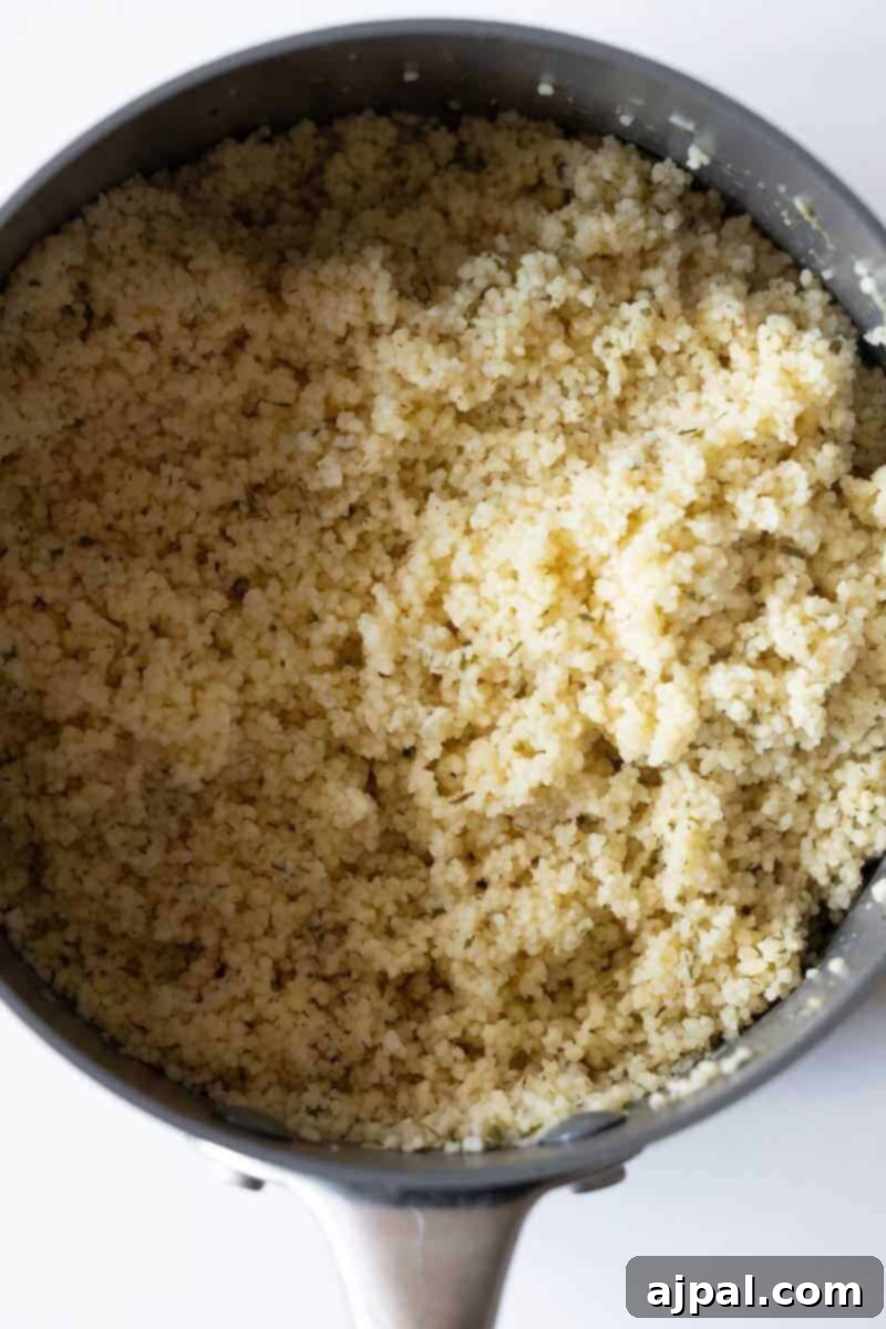 Zucchini Couscous Salad 7 A close-up view of cooked couscous in a pot showcases the fluffy grains, offering inspiration for your next couscous recipe.