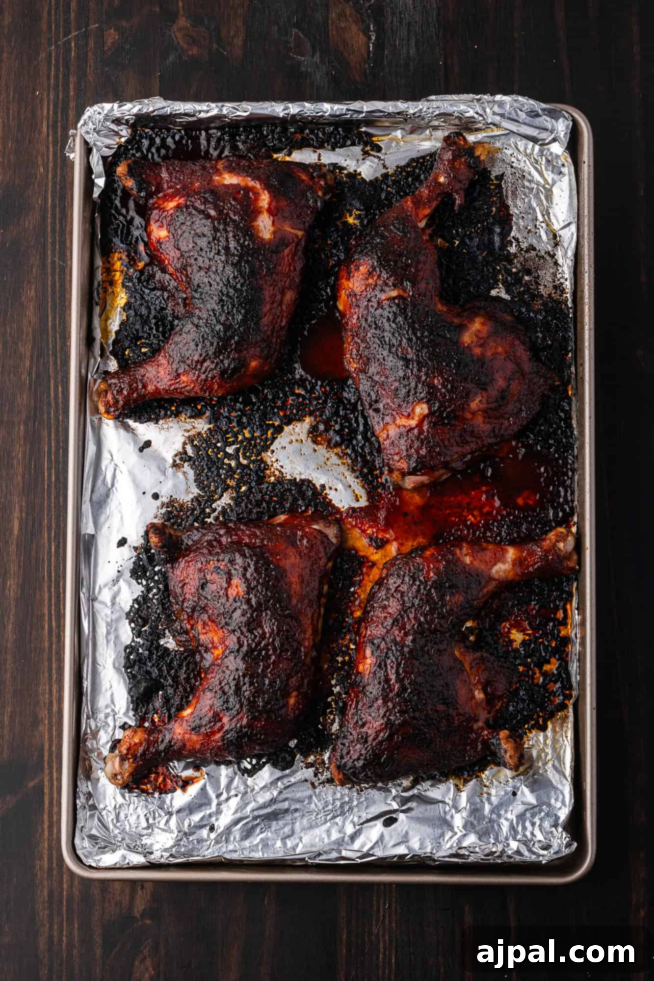 Juicy BBQ Chicken Quarters 11 BBQ Chicken Quarters with a glossy, dark sauce and herbs.