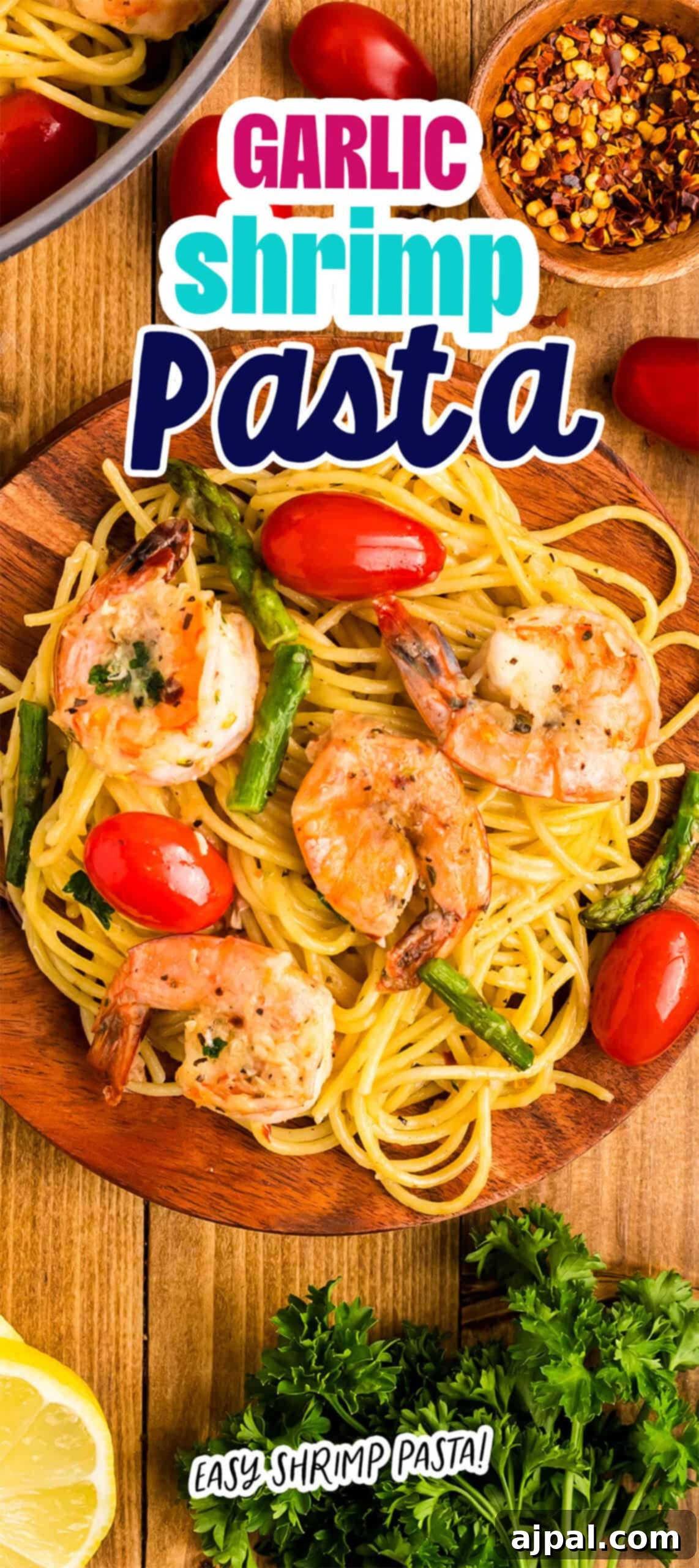 Lemon Garlic Shrimp Pasta 11 A delightful plate of shrimp pasta, infused with the rich aroma of garlic, is accompanied by juicy tomatoes and tender asparagus. It’s beautifully garnished with fresh herbs on a rustic wooden table, creating a perfect culinary masterpiece.