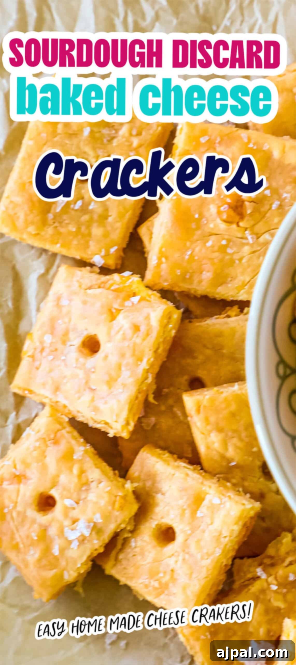 Cheesy Sourdough Discard Crisps 10 Sourdough Cheese Crackers crafted from discard, beautifully presented on parchment paper beside a glimpse of a bowl. Text reads, "Sourdough Discard Baked Cheese Crackers.