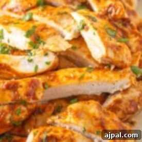 Sliced, thin chicken breasts seasoned with herbs and spices, grilled to perfection, and garnished with freshly chopped cilantro.
