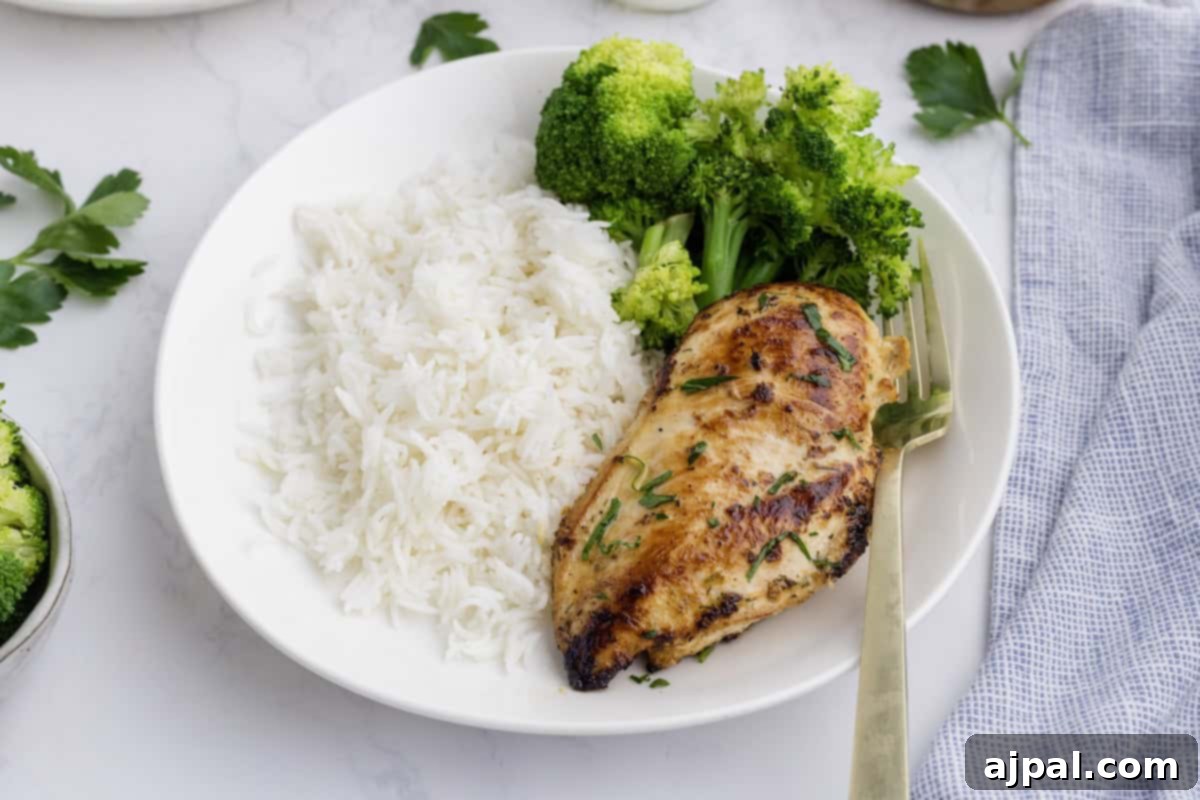Ranch Infused Chicken Breasts 6 A plate with Ranch Chicken Breasts, steamed broccoli, and white rice, served with a gold fork on a white surface.