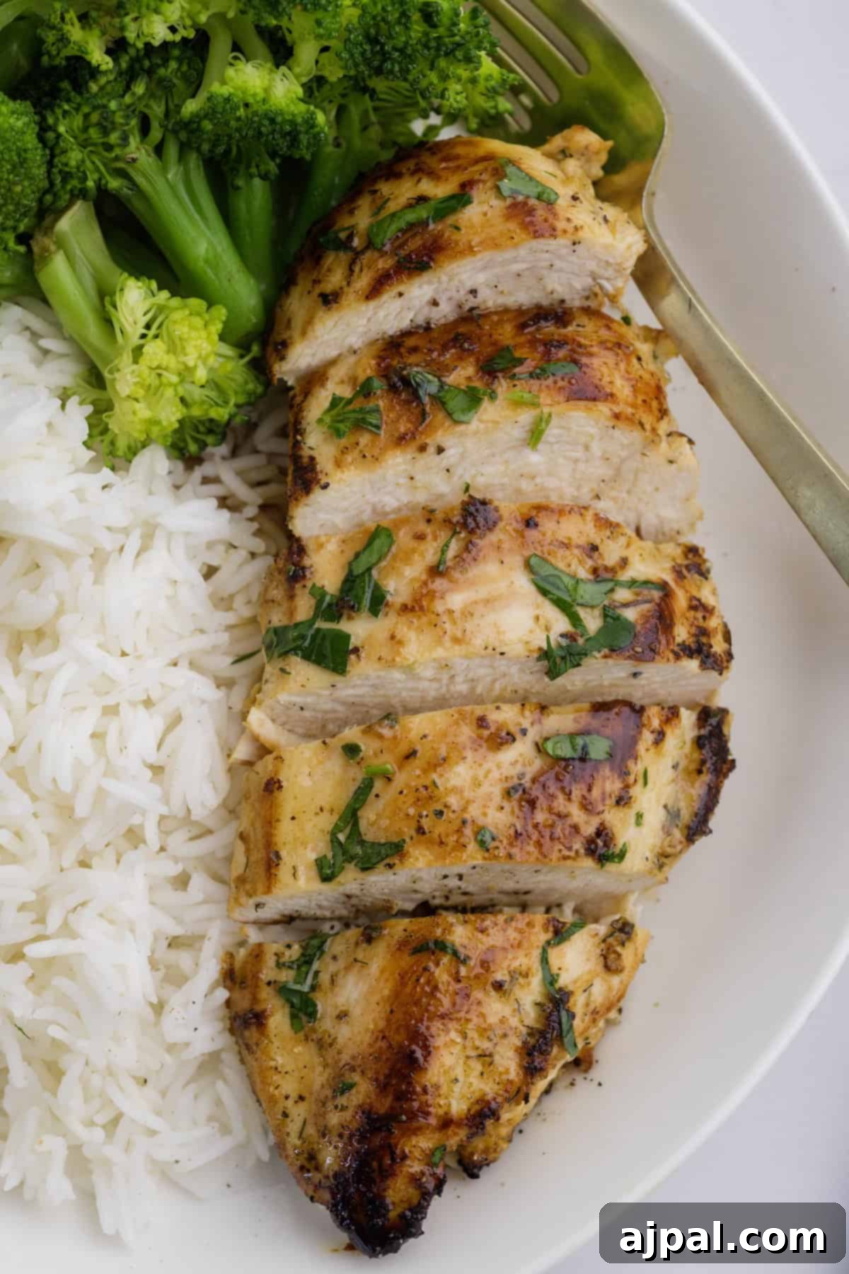 Ranch Infused Chicken Breasts 7 A plate with sliced ranch chicken breasts, white rice, and steamed broccoli.