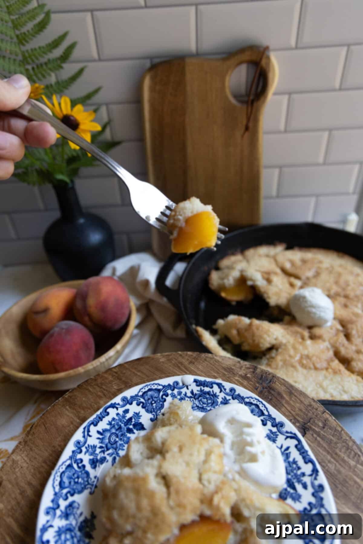Tangy Sourdough Peach Cobbler 3 Delicious sourdough peach cobbler served in a cast iron skillet, showcasing its crispy edges and bubbling fruit filling, ready to be enjoyed.