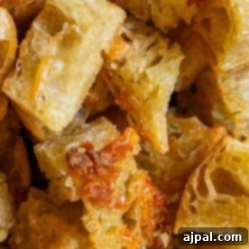 Close-up view of several pieces of bread with melted cheese, showing a crispy, golden-brown texture—perfect for making homemade croutons.