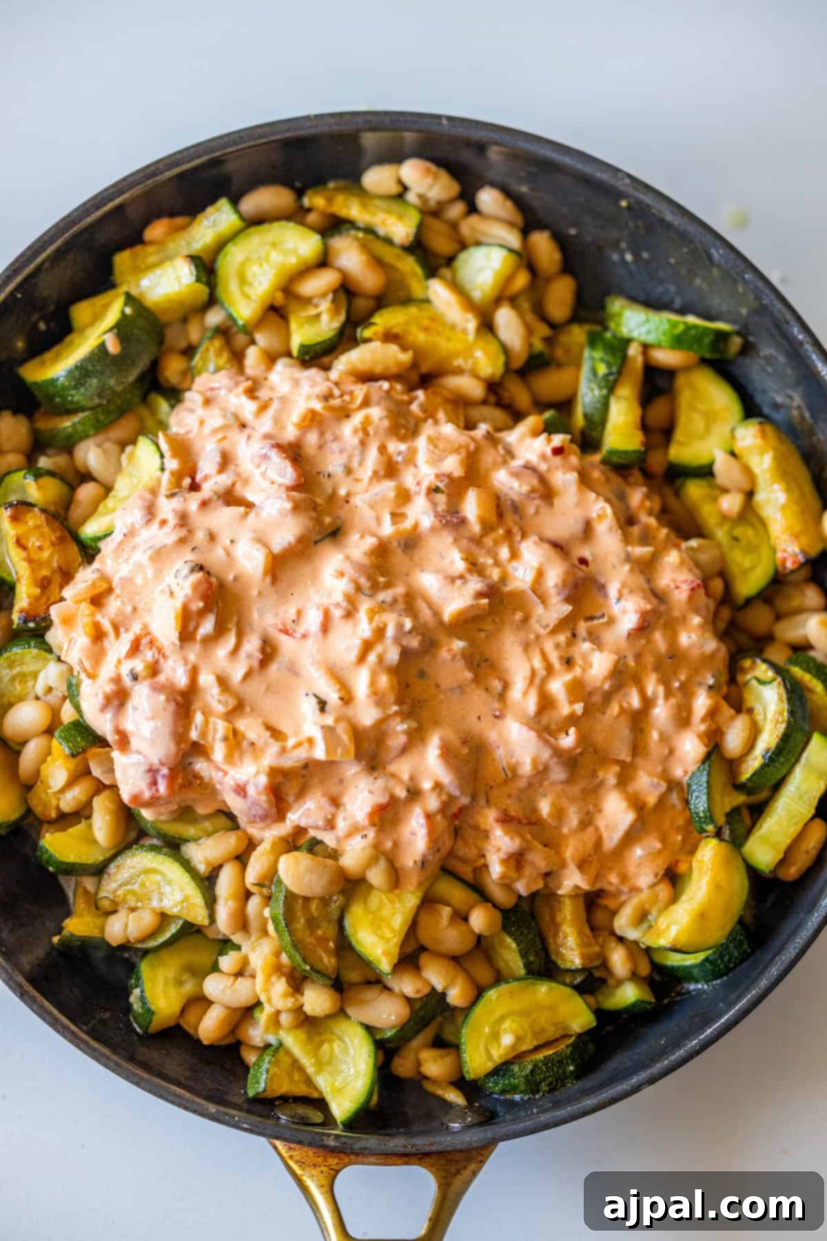 Marry Me Zucchini and Bean Delight 12 Skillet with sautéed zucchini and beans, topped with a creamy Marry Me tomato-based sauce.