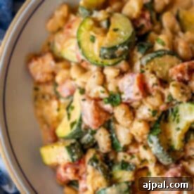 Marry Me Zucchini and Bean Delight 14 Close-up of a bowl containing a creamy mixture of beans, zucchini slices, diced tomatoes, and herbs—flavors that truly marry me in every bite.