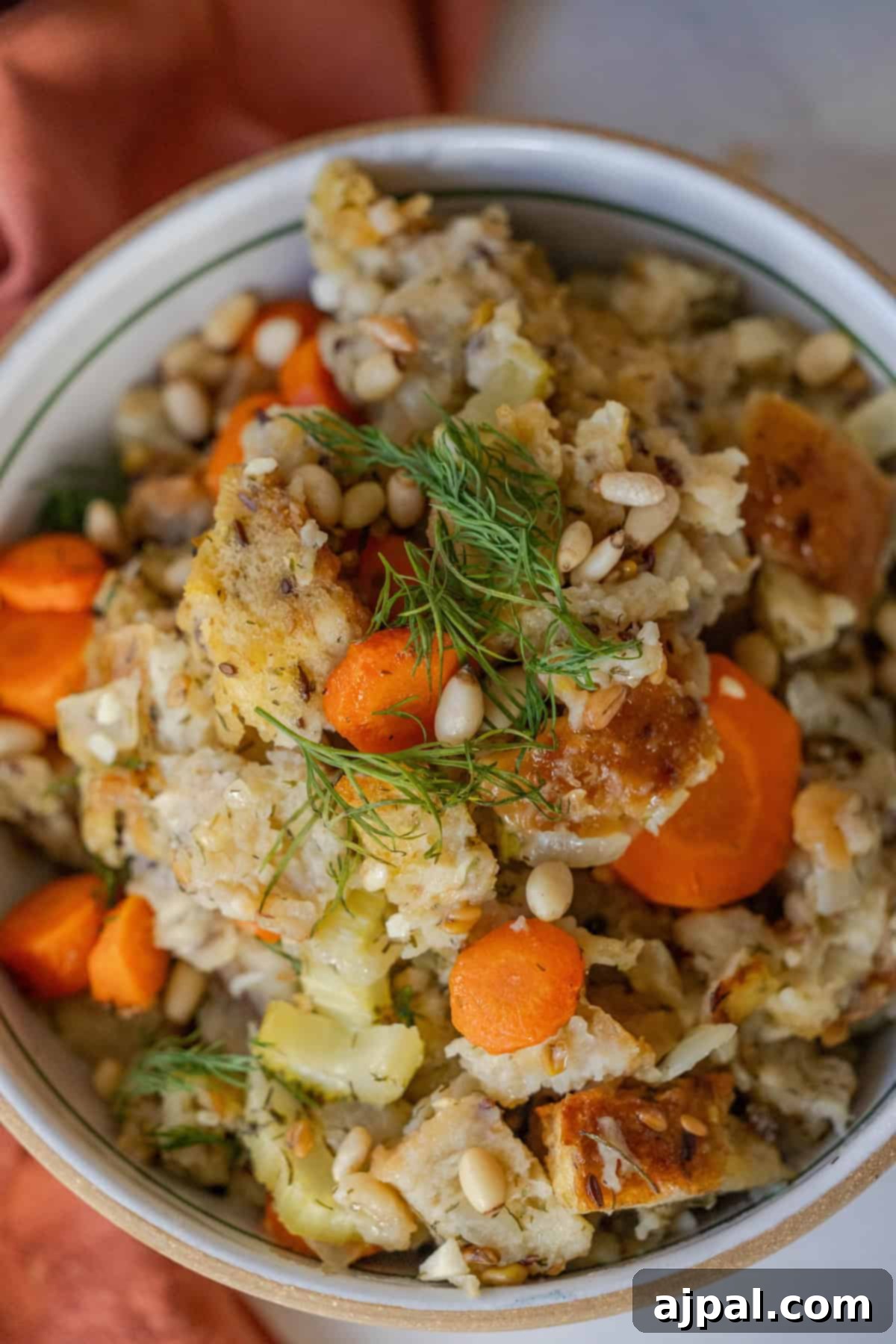 Golden Harvest Stuffing 3 A bowl of mixed vegetables and bread, topped with pine nuts and fresh herbs, offers a delightful Greek-flavored stuffing.