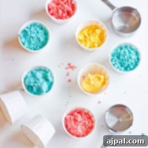 Colorful sprinkles and small bowls on a white surface for making homemade gluten-free moon sand, showcasing ingredients.