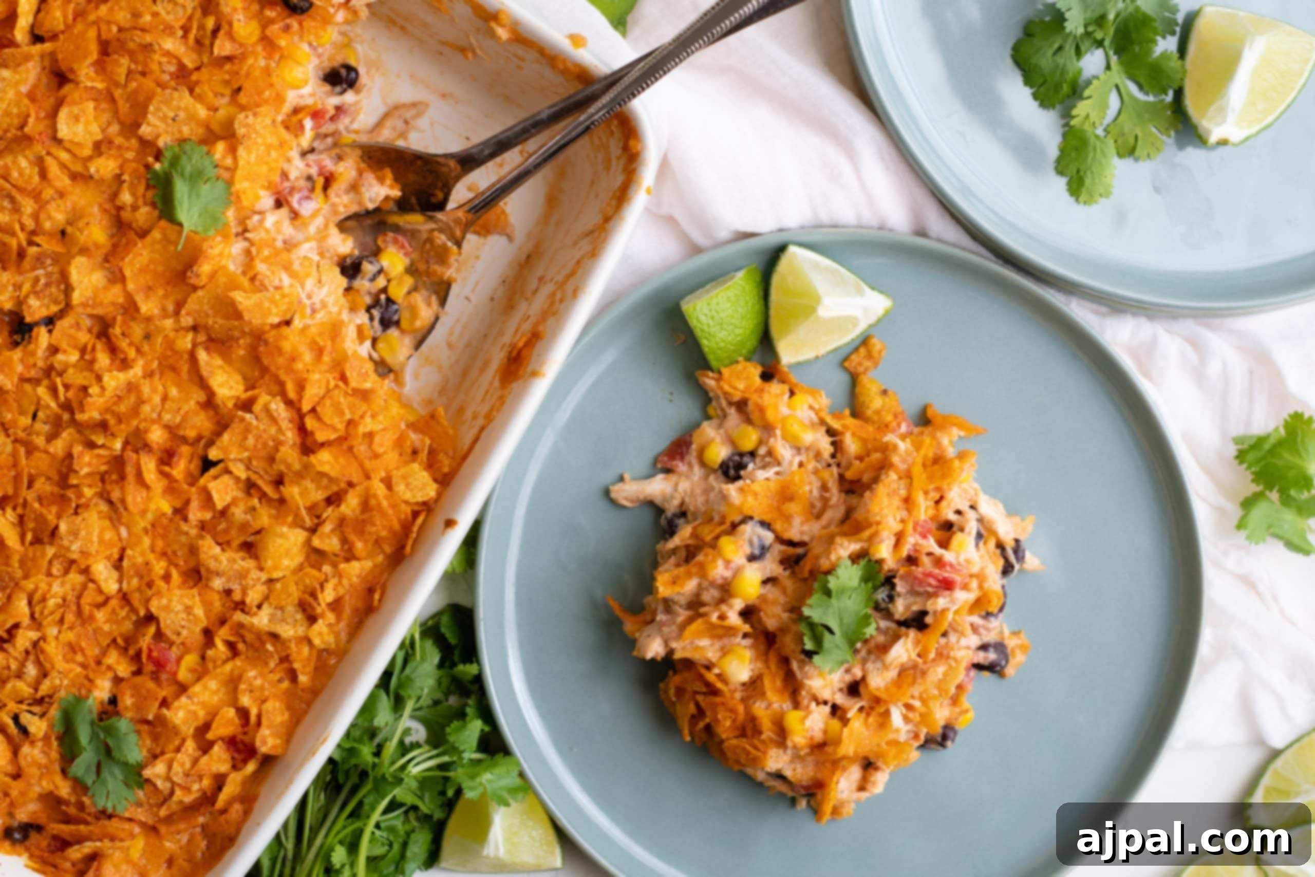 Simple Savory Chicken Bakes 12 A plate of Easy Doritos Chicken Casserole, garnished with fresh lime wedges, showcasing a crunchy, cheesy topping over a savory chicken filling.